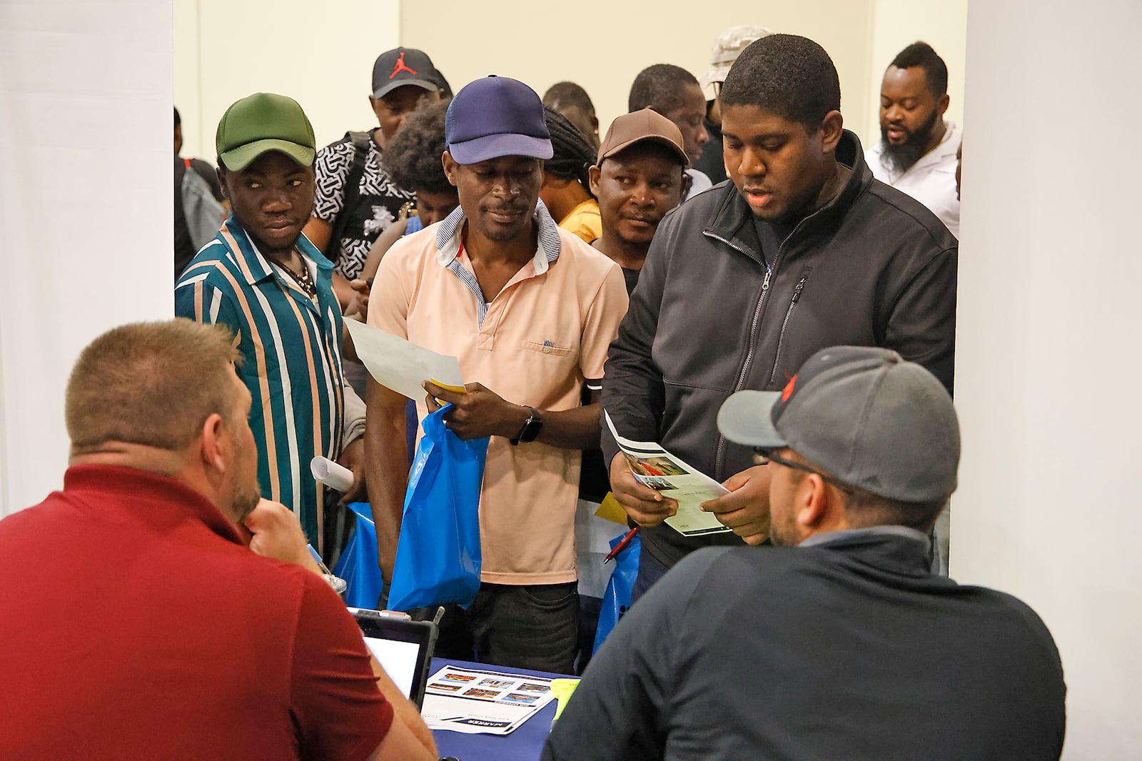 Members of Springfield's Haitian community gather at an employers booth during the 14th Annual Clark County Job Fair Wednesday, April 17, 2024. The job fair featured 60 employers looking for skilled and unskilled workers.  BILL LACKEY/STAFF