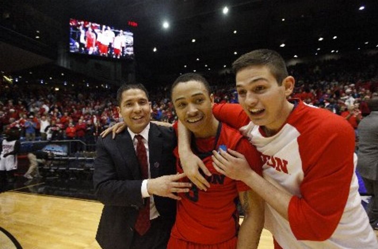 Dayton assistant coach Tom Ostrom, Kyle Davis and Nick Haldes celebrate after a victory against Boise State in the First Four on Wednesday, March 18, 2015, at UD Arena. David Jablonski/Staff