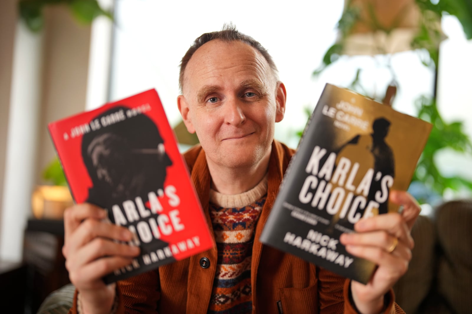 British author Nick Harkaway, son of John le Carre, poses for a photograph with copies of his book, during an interview with The Associated Press, at his home, in London, Thursday, Oct. 24, 2024. (AP Photo/Kin Cheung)