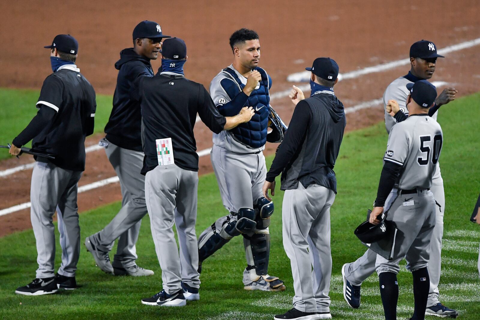 New York Yankees catcher Gary Sánchez, center, and teammates celebrate a 7-2 win over the Toronto Blue Jays in a baseball game in Buffalo, N.Y., Wednesday, Sept. 9, 2020. (AP Photo/Adrian Kraus)