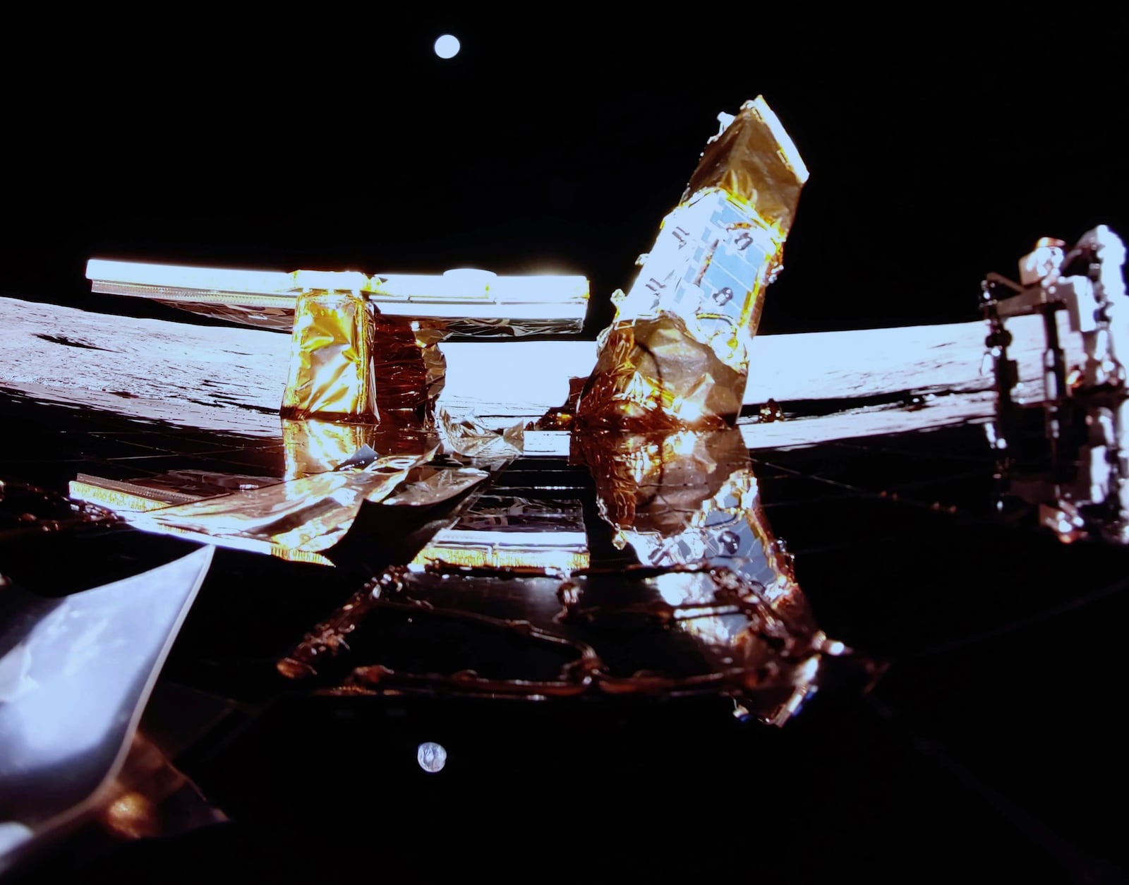 Private lunar lander Blue Ghost after touching down on the moon with a special delivery for NASA Sunday, March 2, 2025. Moon's surface and Earth are visible on the horizon, Blue Ghost's solar panel, X-band antenna, left, and LEXI payload at right. (NASA/Firefly Aerospace via AP)