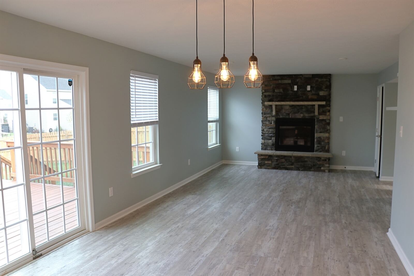 A stack-stone gas fireplace has a raised stone hearth and a stone mantel and is the centerpiece to the living room.