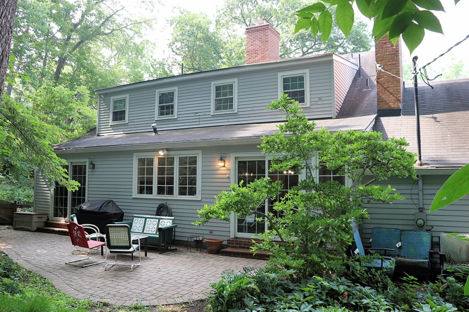 Sliding patio doors open from the hearth room out to the backyard paver patio and private wooded yard.