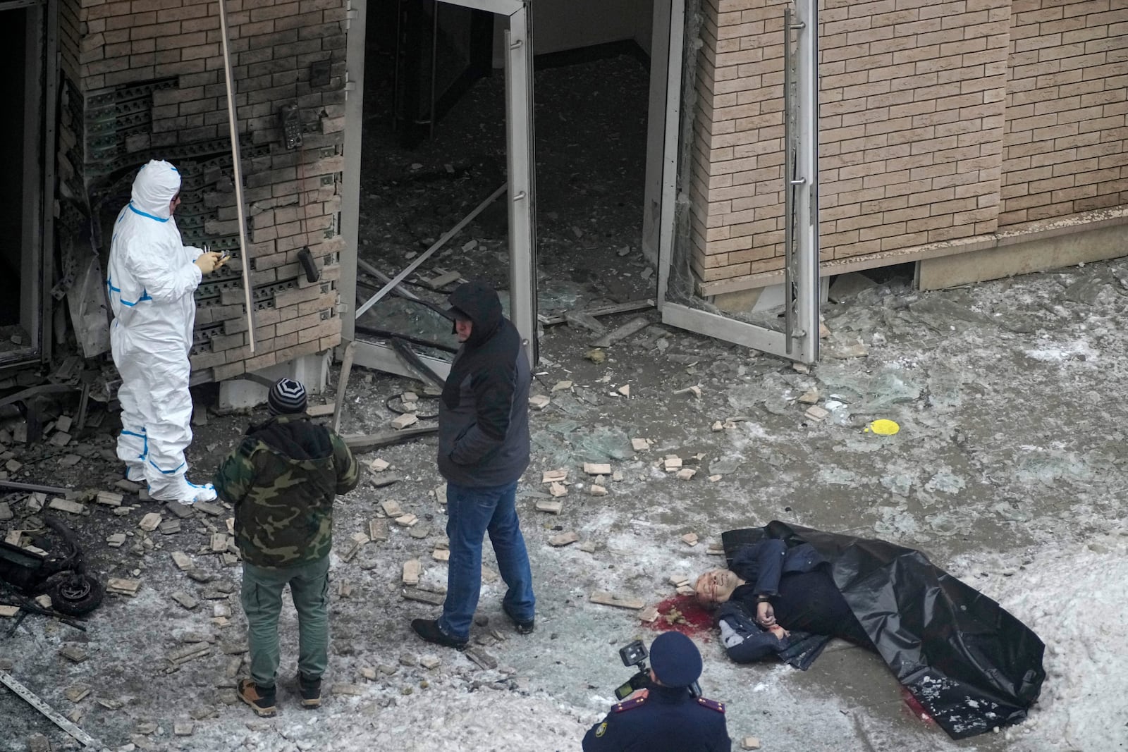 EDS NOTE: GRAPHIC CONTENT - Investigators work at the place where Lt. General Igor Kirillov, right, the head of Russia's Nuclear, Biological, and Chemical Defence Forces and his assistant were killed by an explosive device planted close to a residential apartment's block in Moscow, Russia, Tuesday, Dec. 17, 2024. (AP Photo)