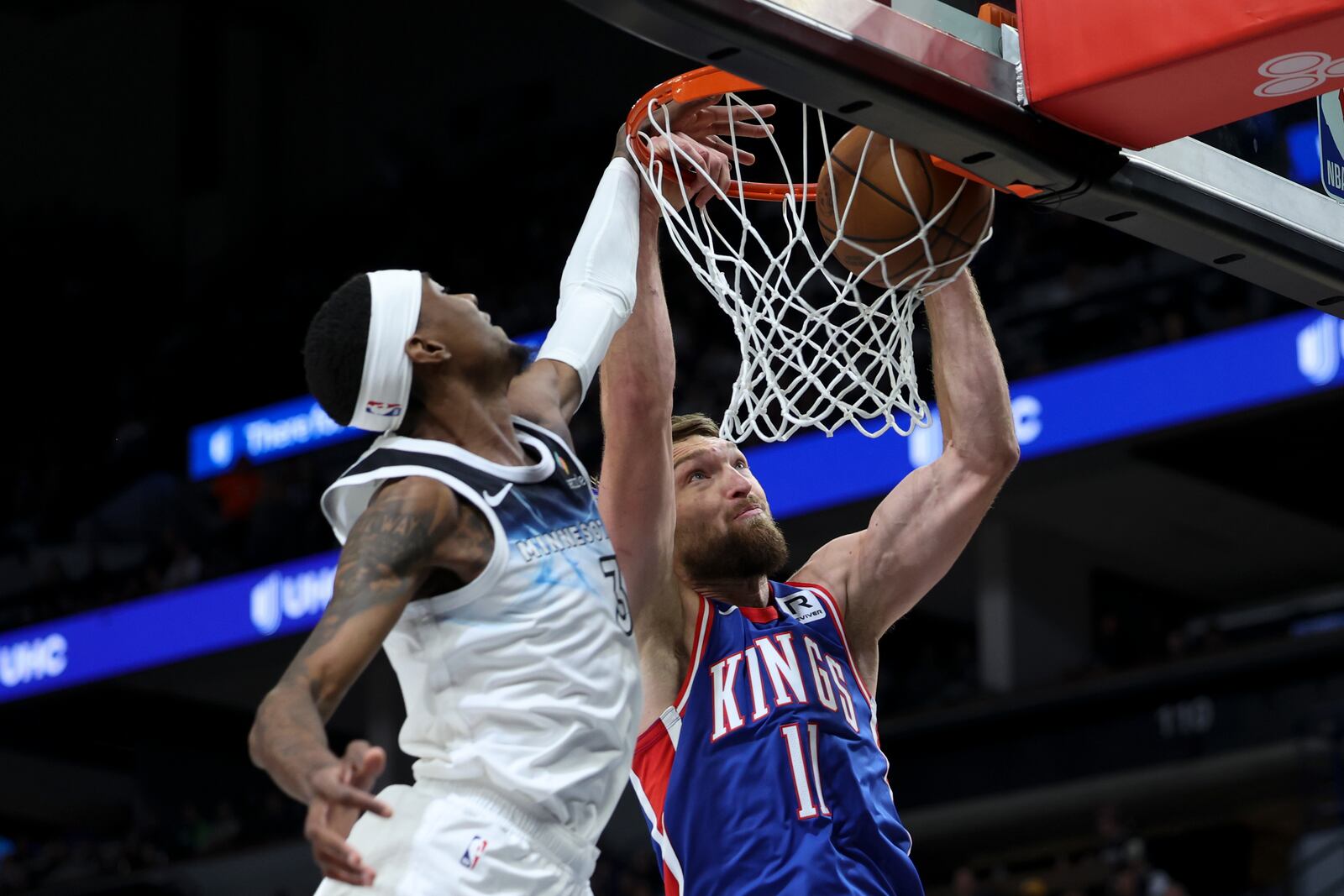 Sacramento Kings forward Domantas Sabonis (11) dunks while Minnesota Timberwolves forward Jaden McDaniels (3) defends during the first half of an NBA basketball game, Wednesday, Nov. 27, 2024, in Minneapolis. (AP Photo/Ellen Schmidt)