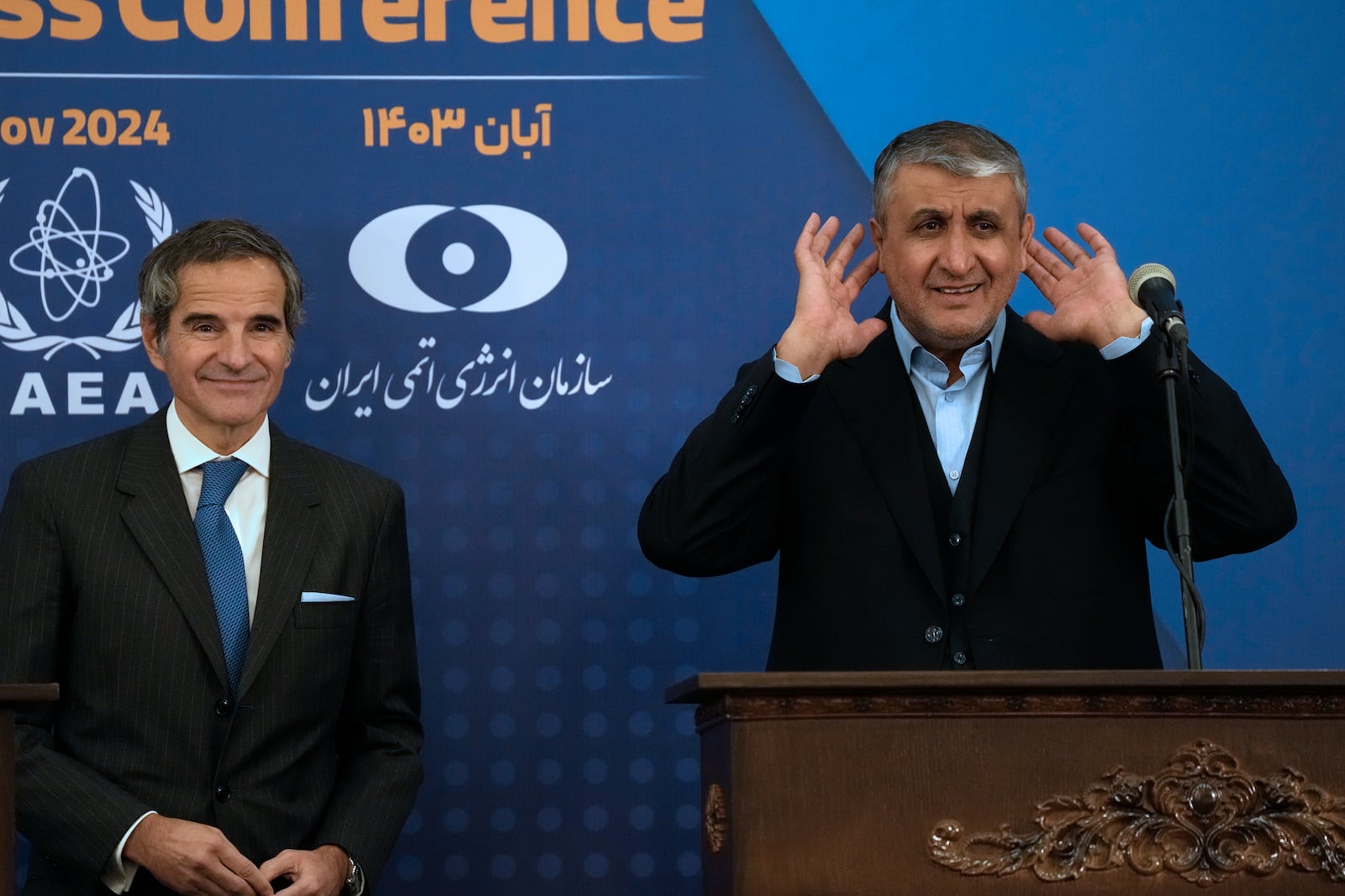 Head of Atomic Energy Organization of Iran Mohammad Eslami, right, tries to listen to a journalist at the conclusion of his joint press conference with International Atomic Energy Agency (IAEA) Director General Rafael Mariano Grossi in Tehran, Iran, Thursday, Nov. 14, 2024. (AP Photo/Vahid Salemi)