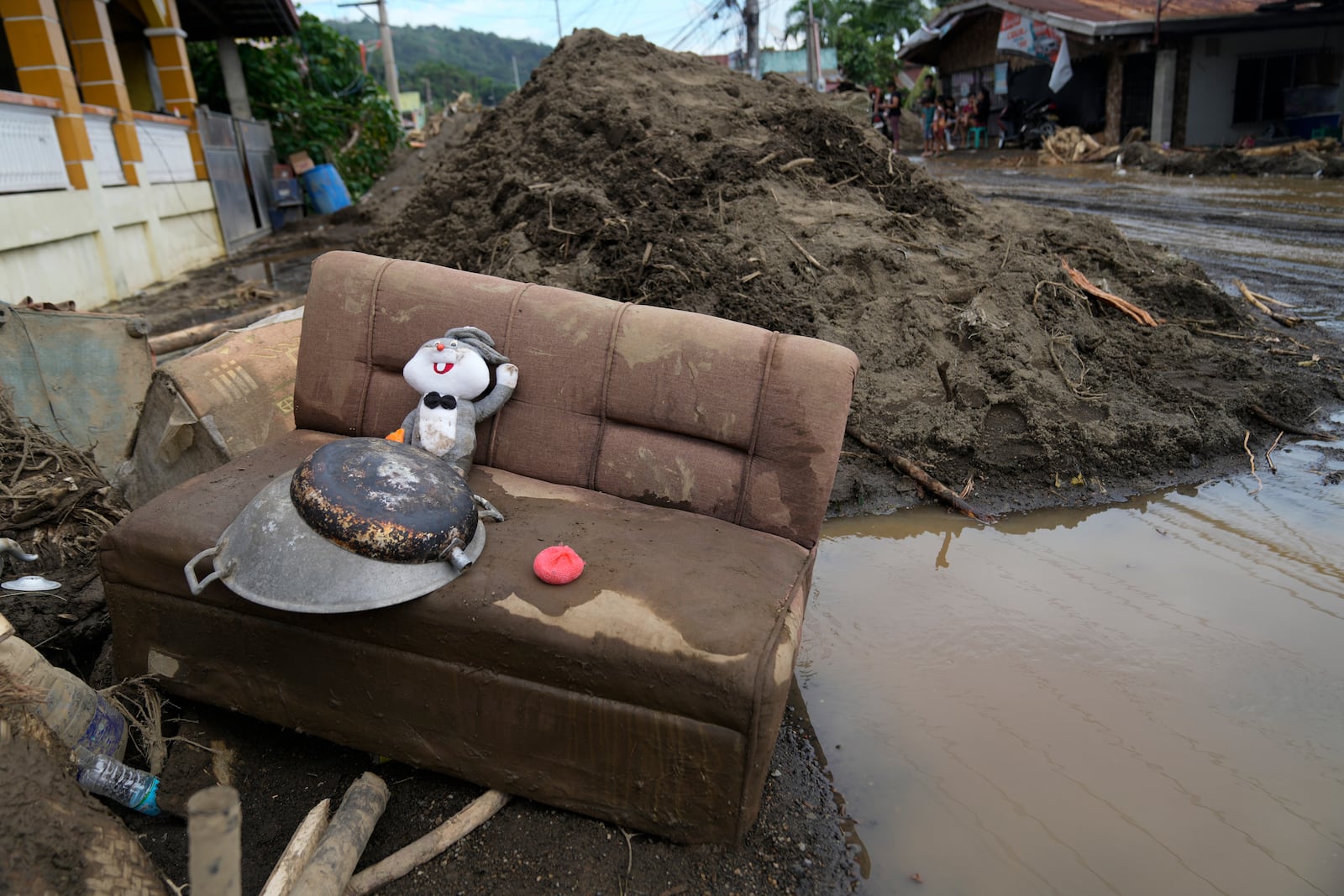 A rabbit doll sits on a mud-covered sofa after a landslide triggered by Tropical Storm Trami struck homes in Talisay, Batangas province, Philippines on Saturday, Oct. 26, 2024. (AP Photo/Aaron Favila)