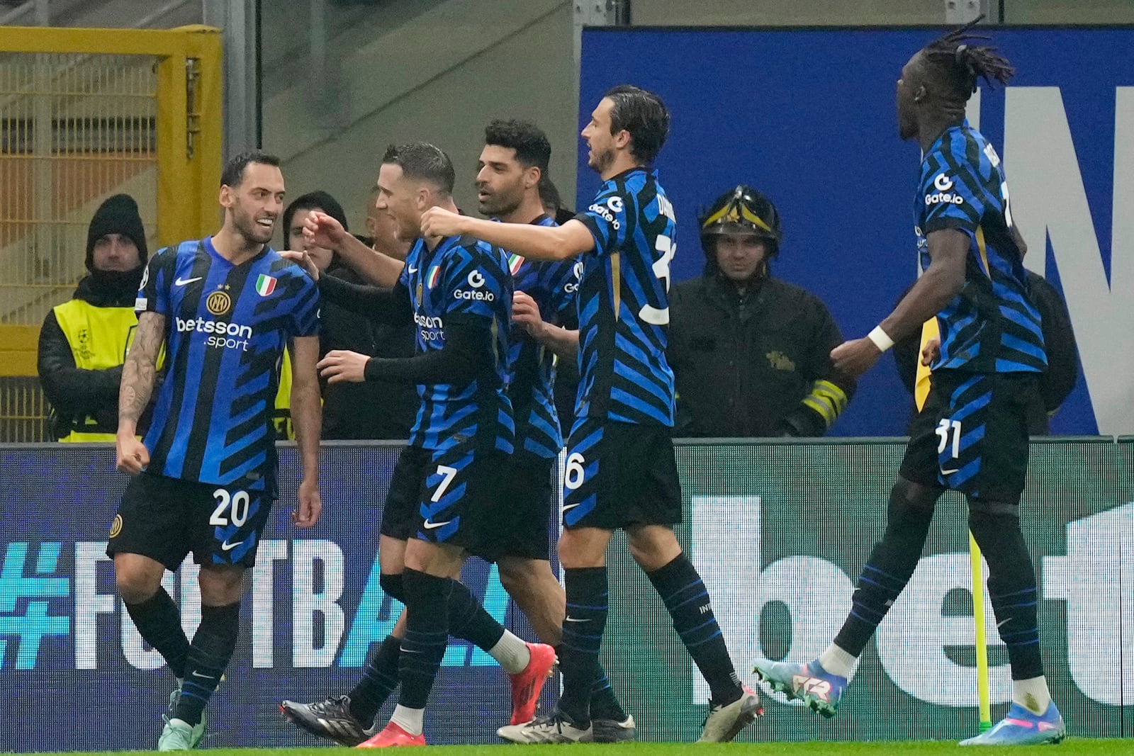 Inter Milan's Hakan Calhanoglu, left, celebrates with his teammates after scoring his side's opening goal during a Champions League opening phase soccer match between Inter Milan and Arsenal at the San Siro stadium in Milan, Italy, Wednesday, Nov. 6, 2024. (AP Photo/Luca Bruno)