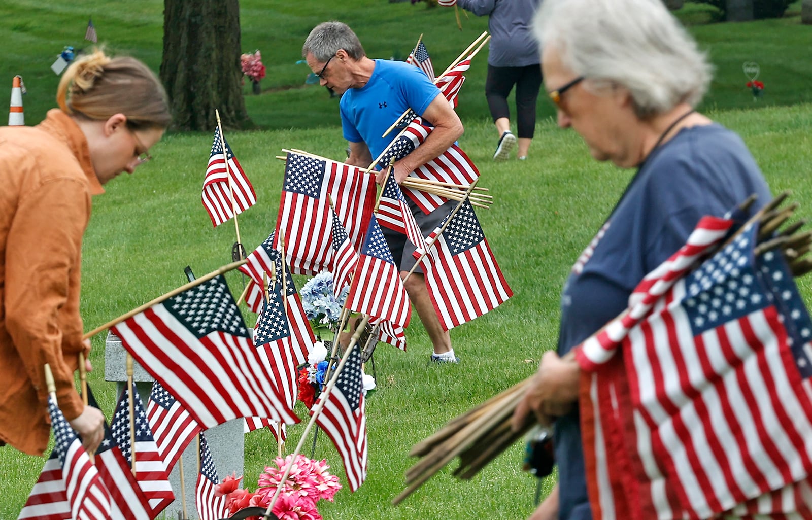 Volunteers were busy Saturday morning, May 18, 2024 placing over 3,000 American flags on the graves of service men and women interred in Ferncliff Cemetery for Memorial Day. Over 40 volunteers, including a large group from Werner Enterprises, placed flags on the central GAR (Civil War) mound, WWI section, WWII section and the Annex with more recent graves. The event was organized by Ferncliff Cemetery and Arboretum. BILL LACKEY/STAFF