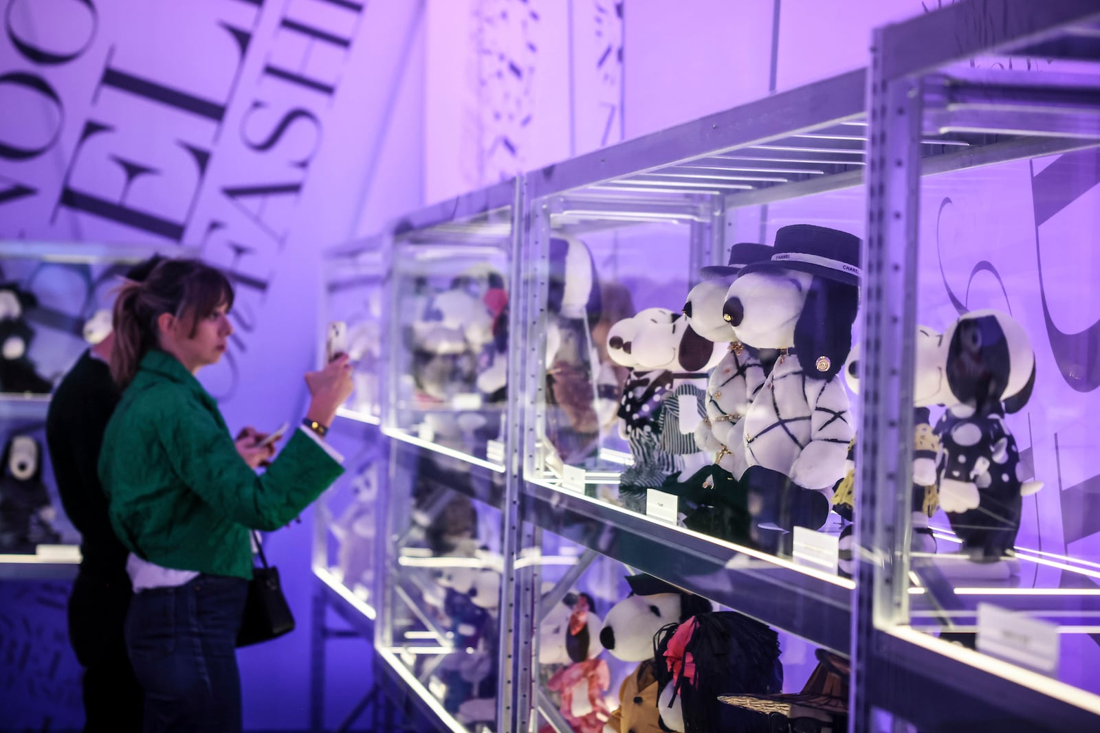 People watch figurines representing Snoopy wear creations as part of Peanuts' 75th Anniversary, at the Snoopy In Style exhibition that runs from March 22 through April 5, in Paris, Thursday, March 20, 2025. (AP Photo/Thomas Padilla)