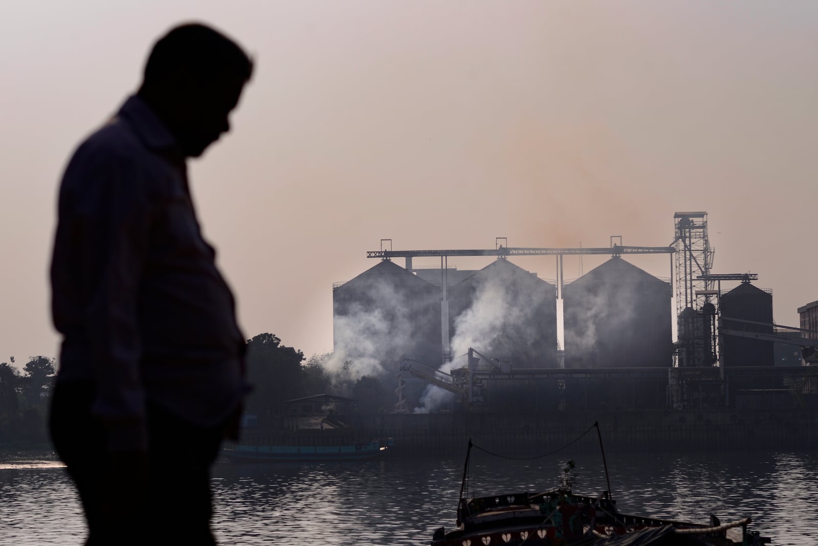 A man walks past an industrial plant in Dhaka, Bangladesh, on Feb. 9, 2025. (AP Photo/Mahmud Hossain Opu)