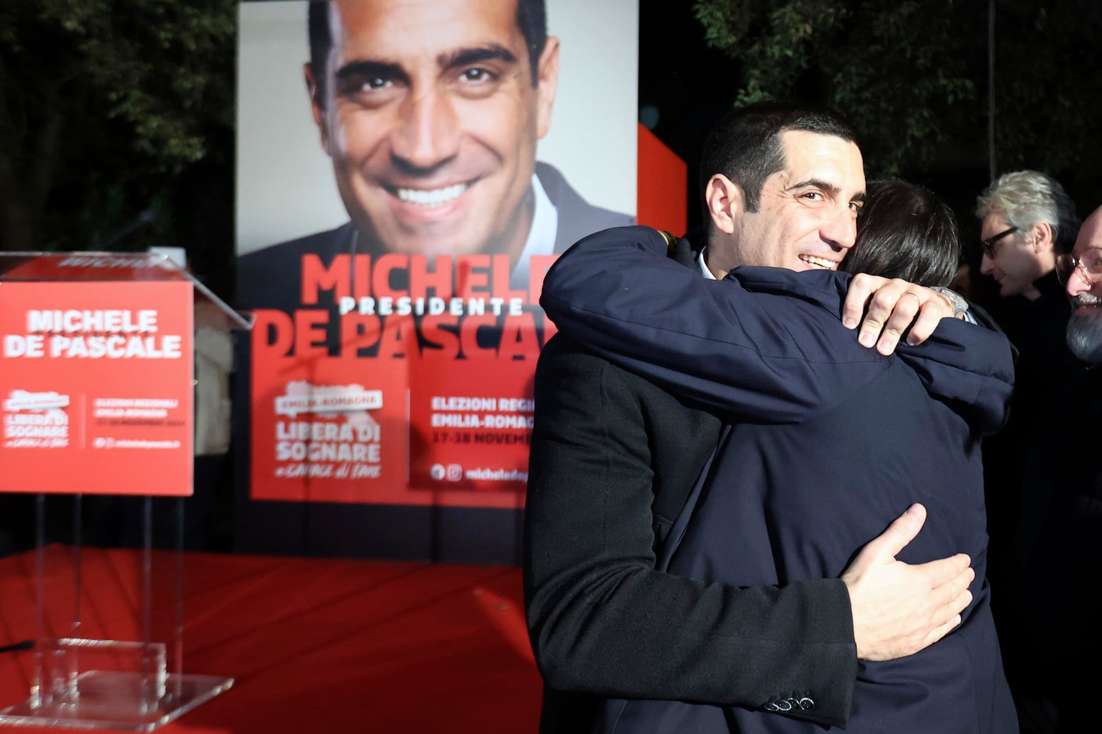 Democratic Party leader Elly Schlein, right, hugs candidate for the presidency of the region of Emilia Romagna Michele de Pascale, following regional elections, in Bologna, Italy, Monday, Nov. 18, 2024. (Guido Calamosca/LaPresse via AP)