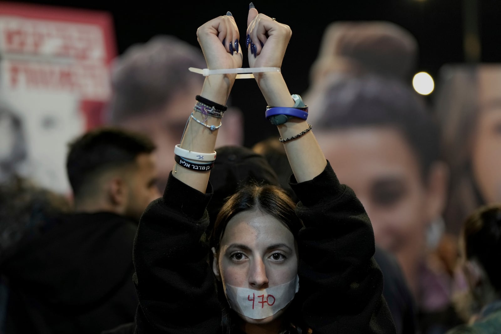 Demonstrators calling for the release of all hostages gather during a protest in Tel Aviv, Israel, as Israel's security cabinet convened to decide whether to approve a deal that would release dozens of hostages held by militants in Gaza and pause the 15-month-war Saturday, Jan. 18, 2025. (AP Photo/Oded Balilty)