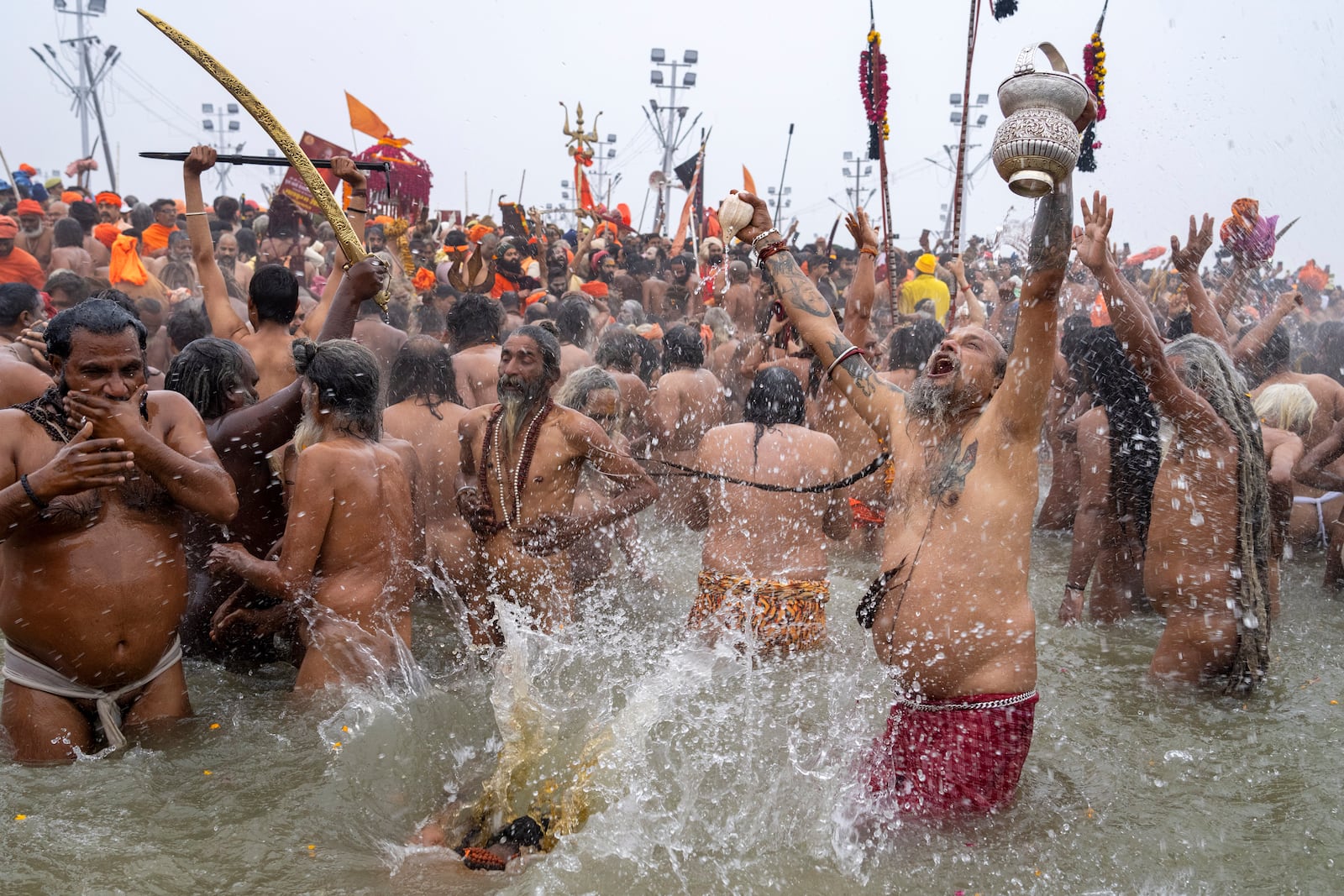 Hindu ascetics and holy men bathe at the confluence of the Ganges, the Yamuna and the mythical Saraswati rivers on the second day of the 45-day-long Maha Kumbh festival in Prayagraj, India, Tuesday, Jan. 14, 2025. (AP Photo/Ashwini Bhatia)