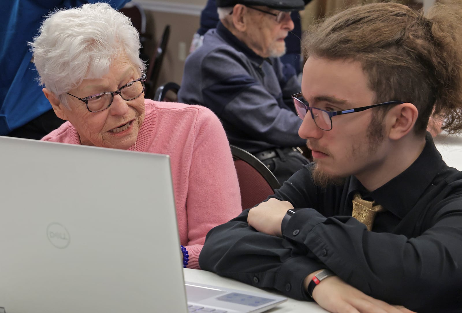 Elizabeth Damewood, a resident at Oakwood Village retirement community, asks Clayton Shumway, a CTC Cybersecurity student, a question about her laptop computer Monday, Feb. 24, 2024. Clayton and several other cybersecurity students visited Oakwood Village to talk about how to avoid scams on the internet and answer any questions the residents had about their portable devices. BILL LACKEY/STAFF