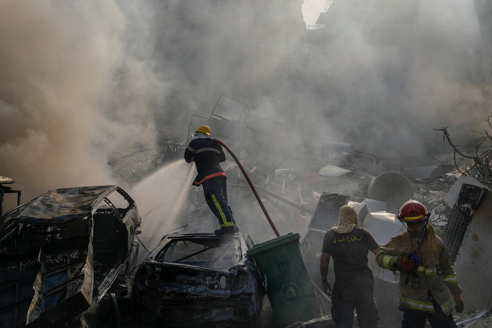 Civil defense workers extinguish a fire as smoke rises from the site of an Israeli airstrike in Dahiyeh, Beirut, Lebanon, Friday, Nov. 1, 2024. (AP Photo/Hassan Ammar)