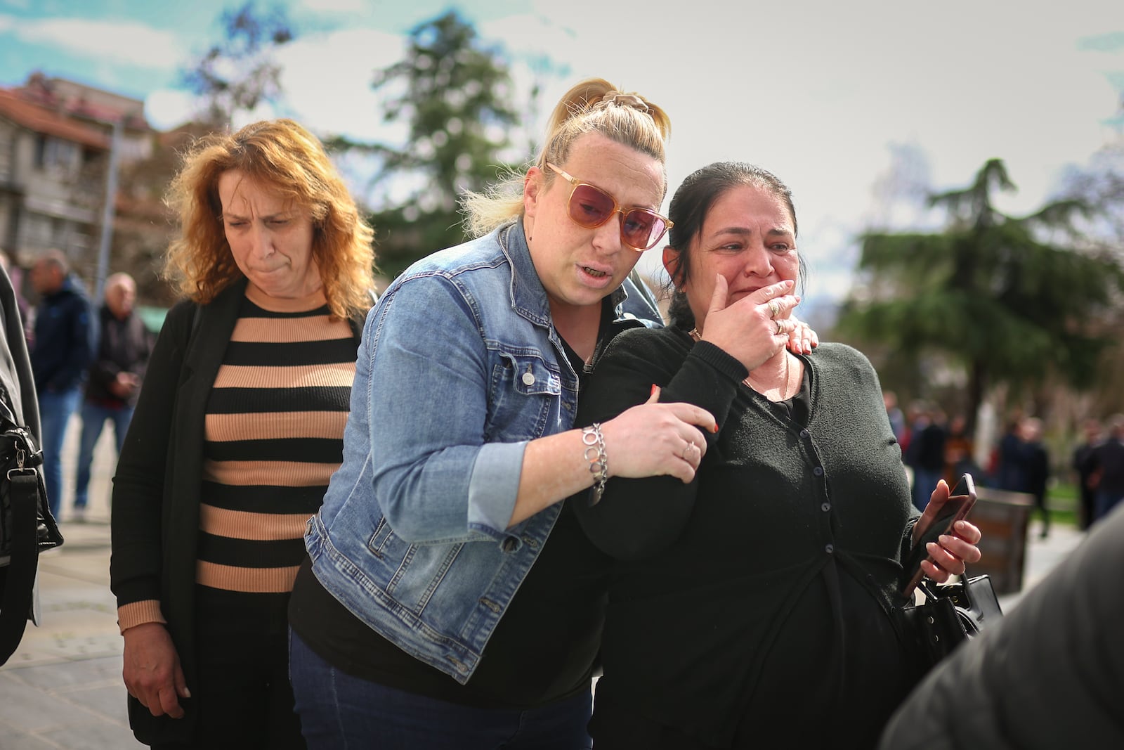 A woman cries while waiting in line to write condolence messages for the victims of a massive nightclub fire in the town of Kocani, North Macedonia, Monday, March 17, 2025, (AP Photo/Armin Durgut)