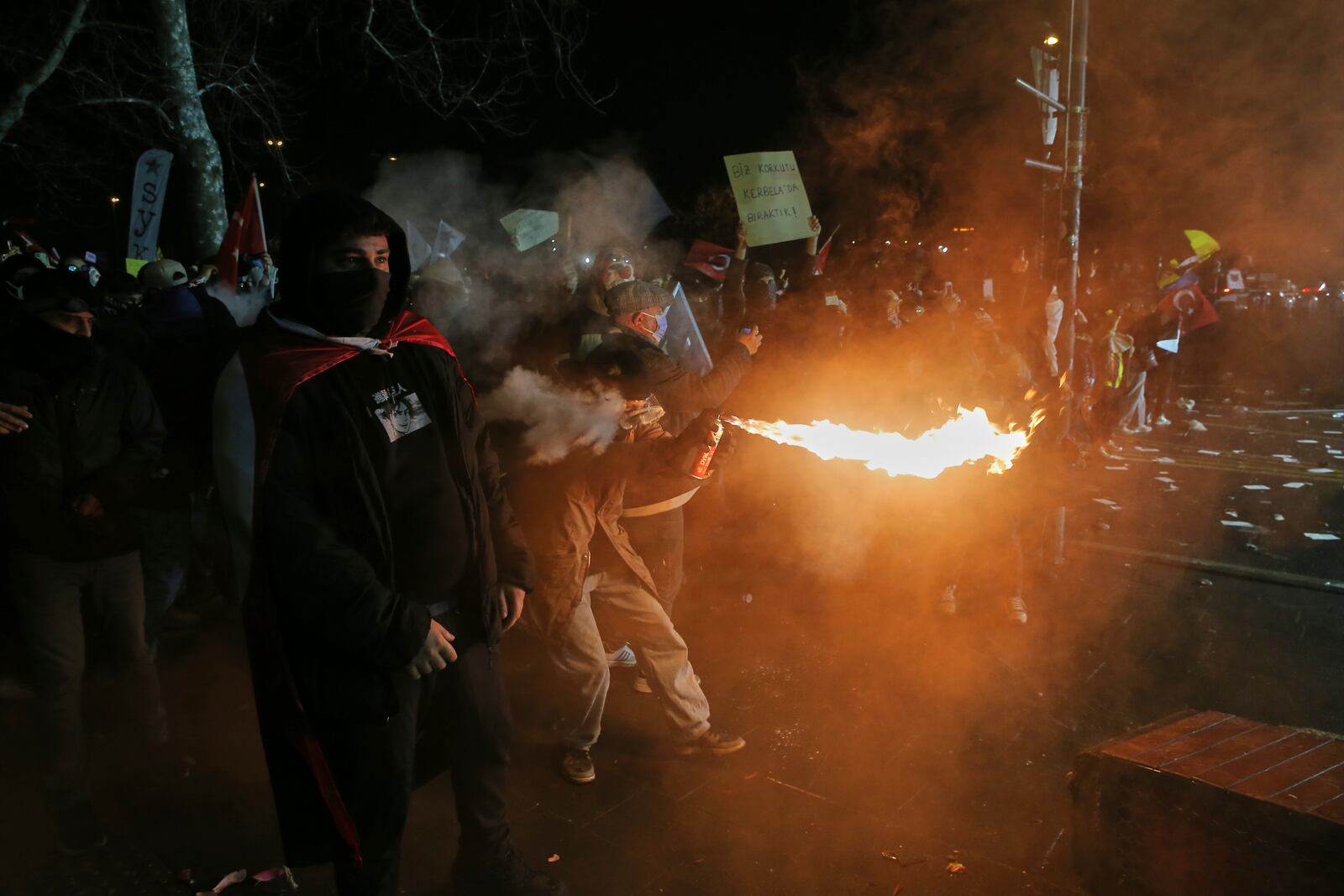 A protester sprays fire against riot policemen during a protest after Istanbul's Mayor Ekrem Imamoglu was arrested and sent to prison, in Istanbul, Turkey, Sunday, March 23, 2025. (AP Photo/Huseyin Aldemir)