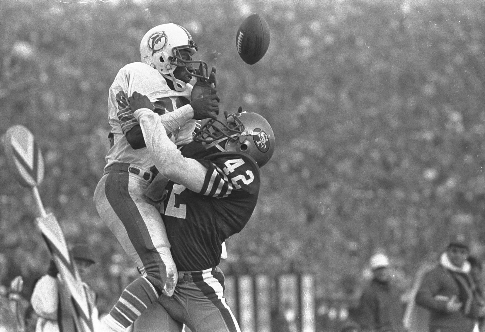 FILE - San Francisco 49ers cornerback Ronnie Lott (42) slams into Miami Dolphins receiver Mark Clayton (83) to break up pass during Super Bowl XIX action Sunday, Jan. 20, 1985 at Stanford Stadium in Palo Alto, Calif. (AP Photo/File)