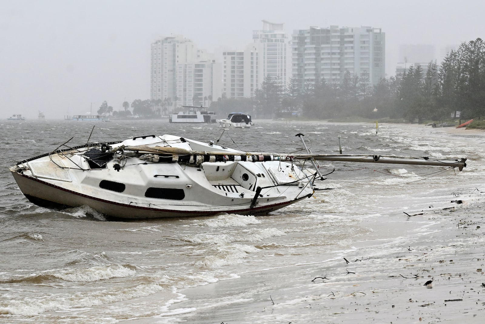 A yacht sits washed ashore in the Broadwater at Labrador following cyclone Alfred on the Gold Coast, Australia, Saturday, March 8, 2025. (Dave Hunt/AAP Image via AP)