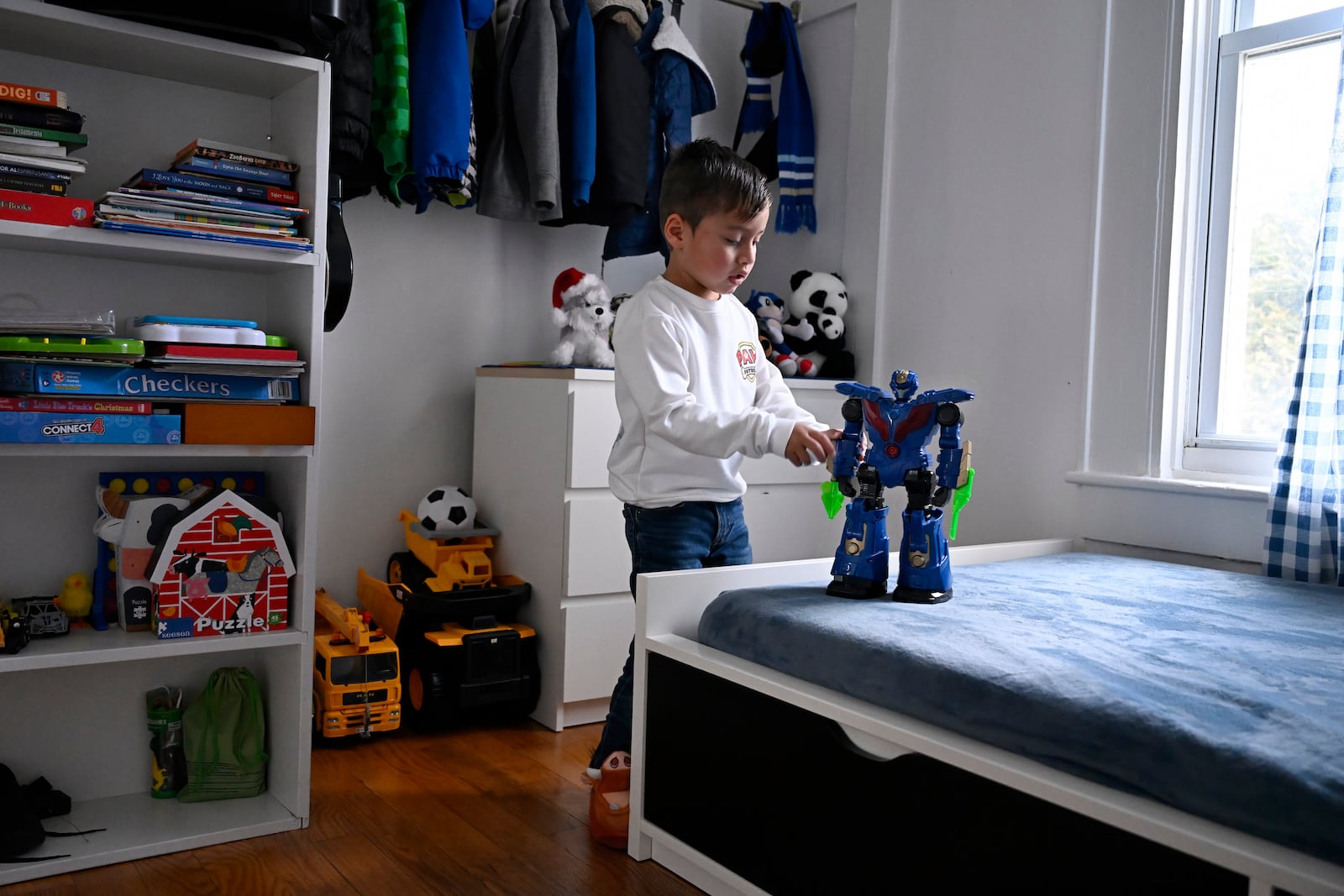 In this Jan. 3, 2025 photo, Jesus Lopez, plays with one of his toys in his apartment in New Milford, Conn. (AP Photo/Jessica Hill)