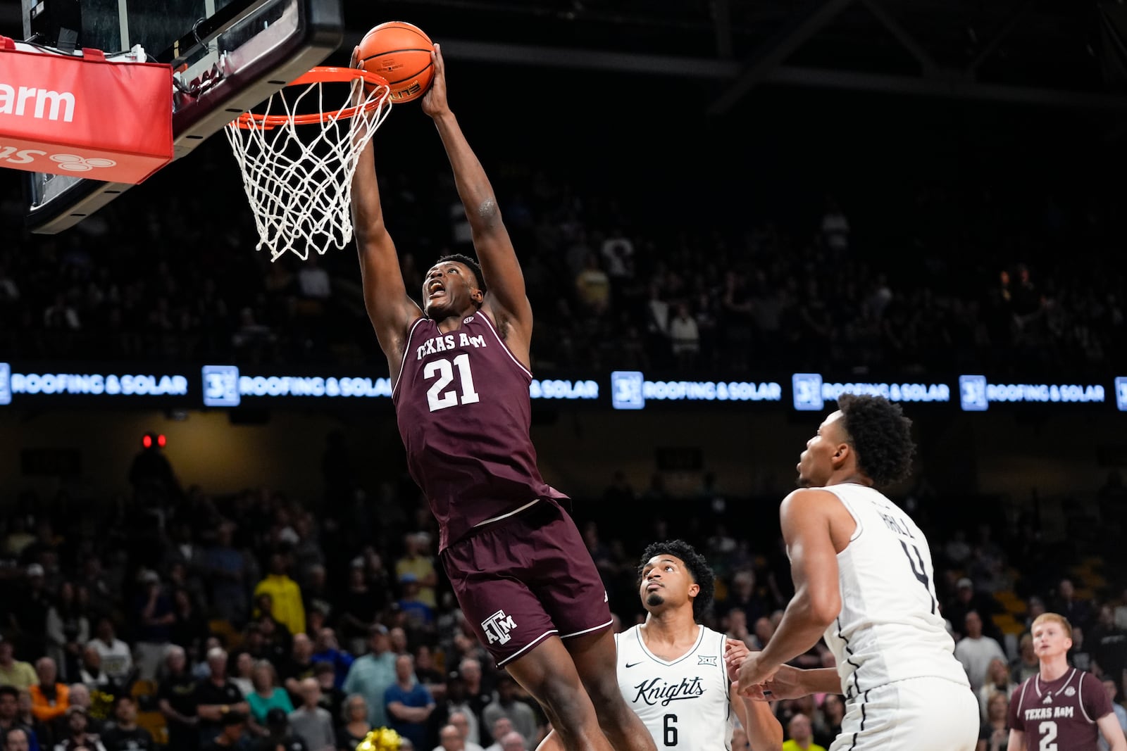 Texas A&M forward Pharrel Payne (21) dunks as he gets past Central Florida guards Dallan Coleman (6) and Keyshawn Hall (4) during the first half of an NCAA college basketball game, Monday, Nov. 4, 2024, in Orlando, Fla. (AP Photo/John Raoux)