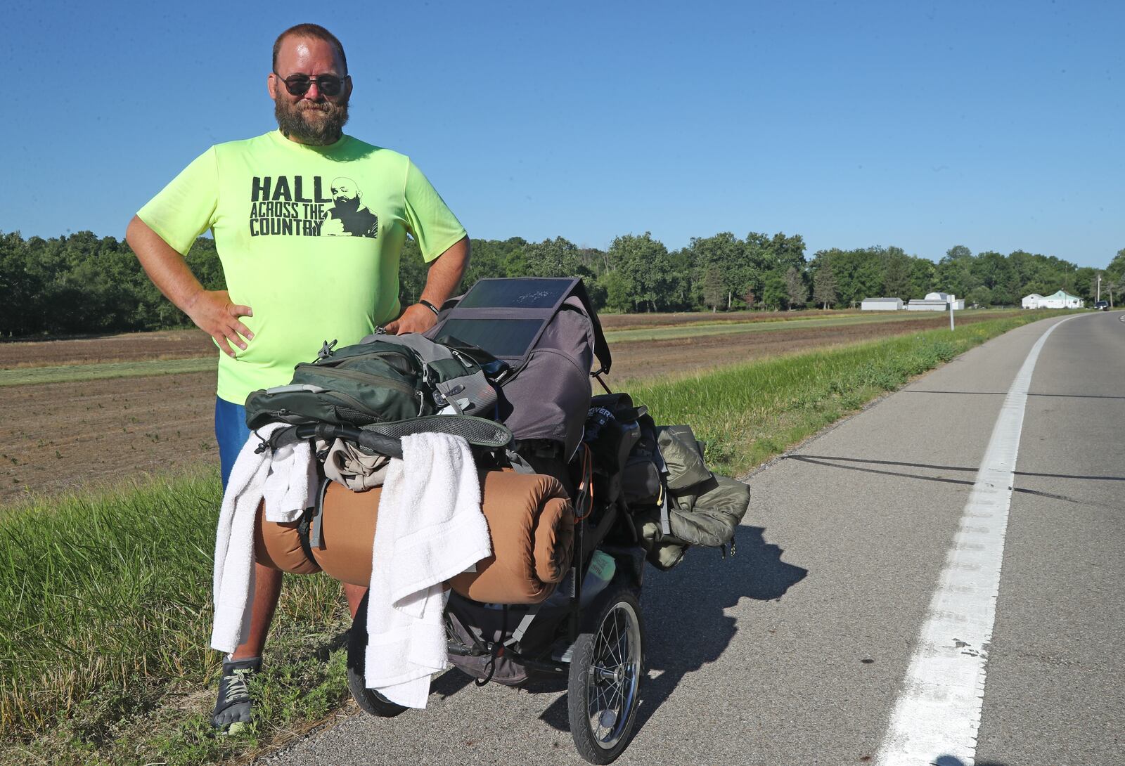 Joe Hall pauses on his journey along U.S. 40 between South Vienna and Springfield on Thursday, June 23, 2022. Hall is walking across America in a fundraiser for Dayton Children's Behavioral Health Unit. BILL LACKEY/STAFF