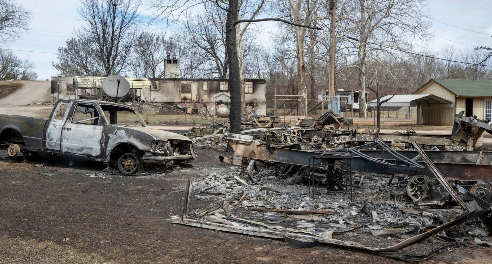 Several RVs and a truck burned from Friday's wildfires not far from a larger structure that burned at Pecan Valley RV Park shown Saturday, March 15, 2025, on the west edge of Stillwater, Okla. (Jason Elmquist/The News Press via AP)