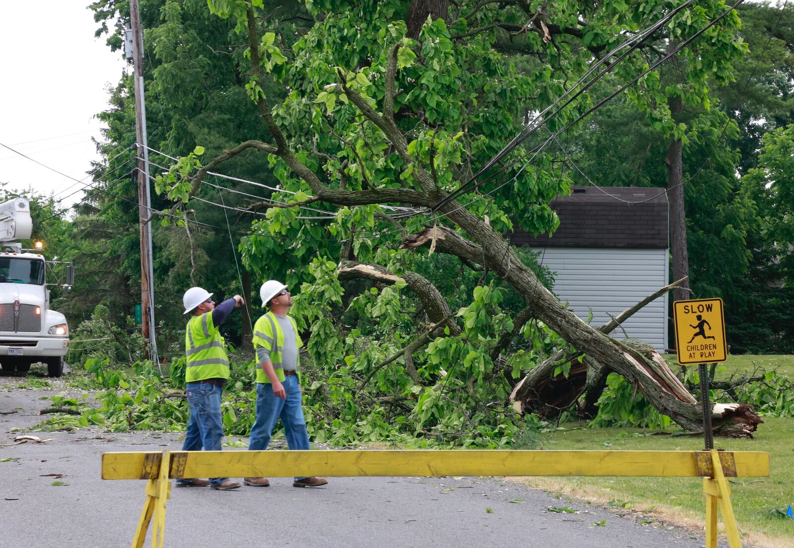 An AES Ohio crew works on Fourth Street in Christiansburg on Monday, June 12, 2023, after Sunday night storms caused power outages in the Champaign County village. BILL LACKEY/STAFF