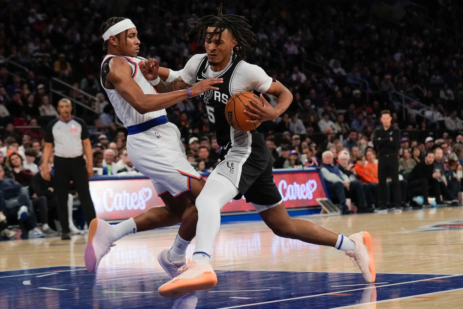 San Antonio Spurs' Stephon Castle, right, drives to the basket past New York Knicks' Miles McBride during the first half of an NBA basketball game, Wednesday, Dec. 25, 2024, in New York. (AP Photo/Seth Wenig)