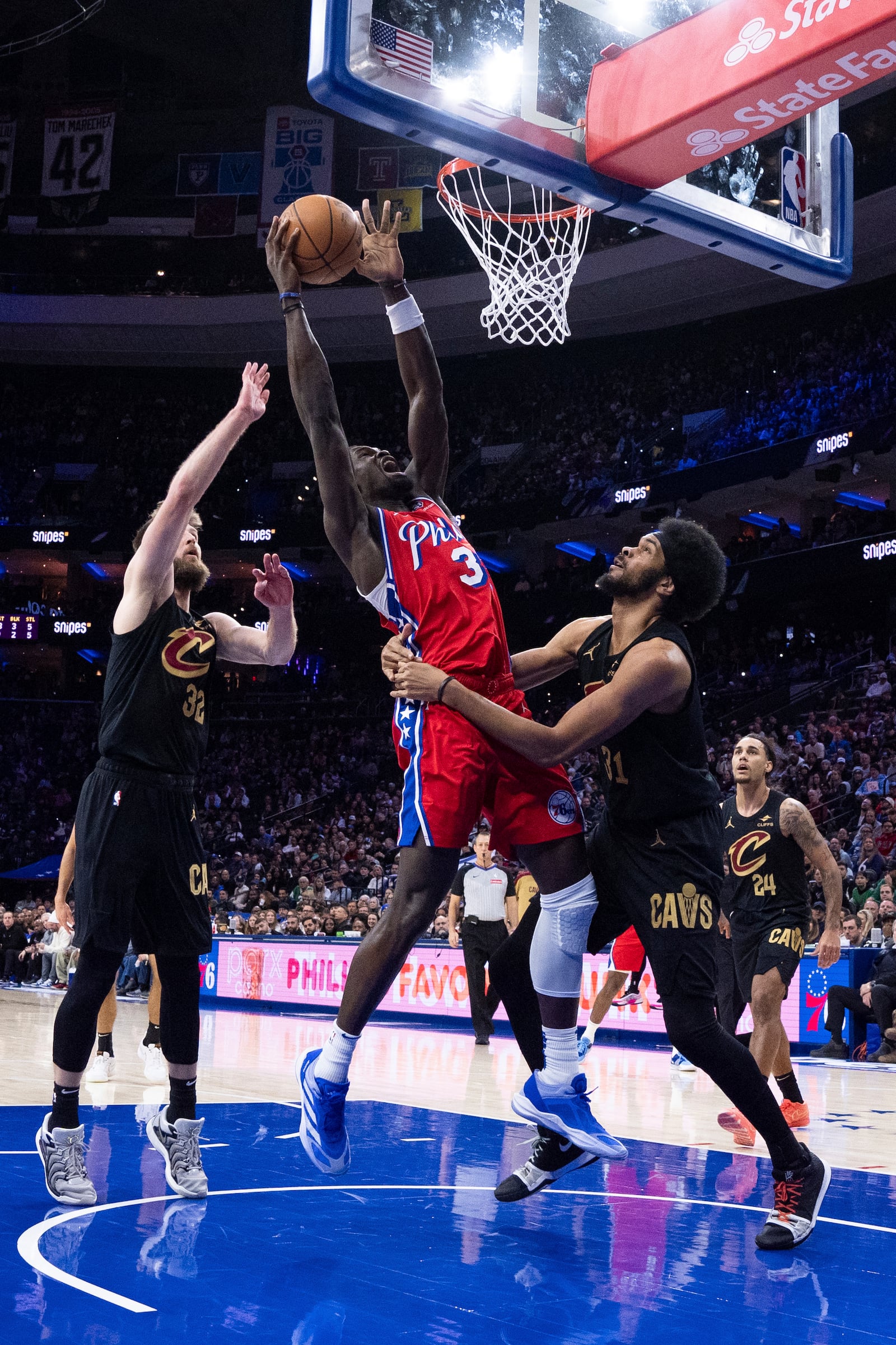 Philadelphia 76ers' Adem Bona, center, grabs a rebound as he is fouled by Cleveland Cavaliers' Jarrett Allen, front right, during the first half of an NBA basketball game, Friday, Jan. 24, 2025, in Philadelphia. (AP Photo/Chris Szagola)