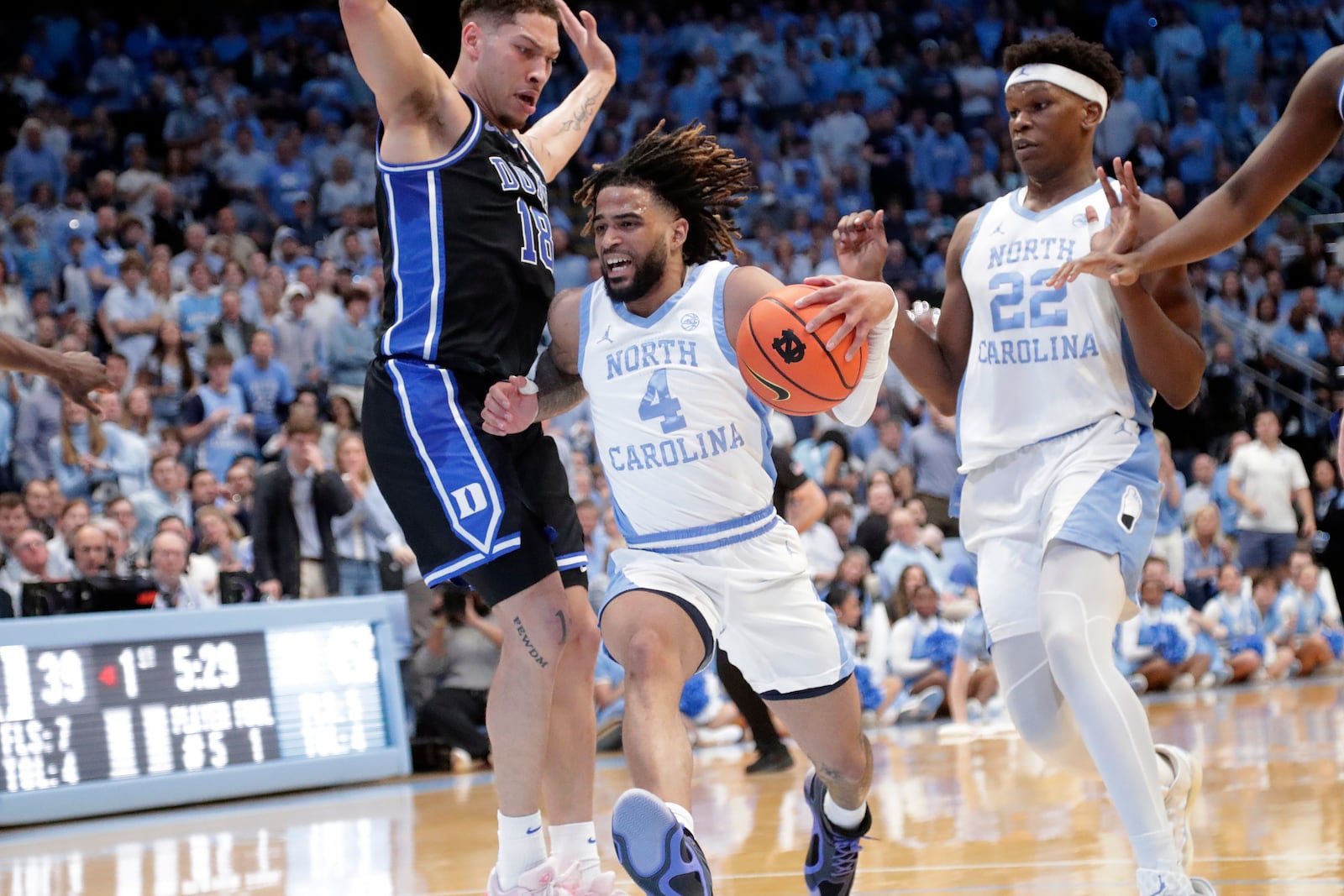 North Carolina guard RJ Davis (4) drives against Duke forward Mason Gillis (18) during the first half of an NCAA college basketball game Saturday, March 8, 2025, in Chapel Hill, N.C. North Carolina forward Ven-Allen Lubin (22) trails at right. (AP Photo/Chris Seward)