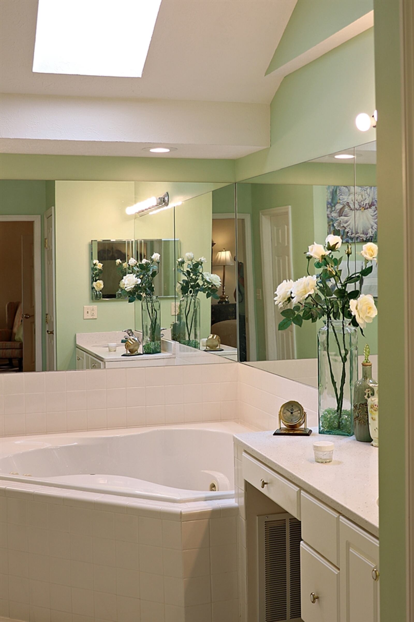 The primary bathroom has a two-person whirlpool tub, dividing the two separate single-sink vanities. 