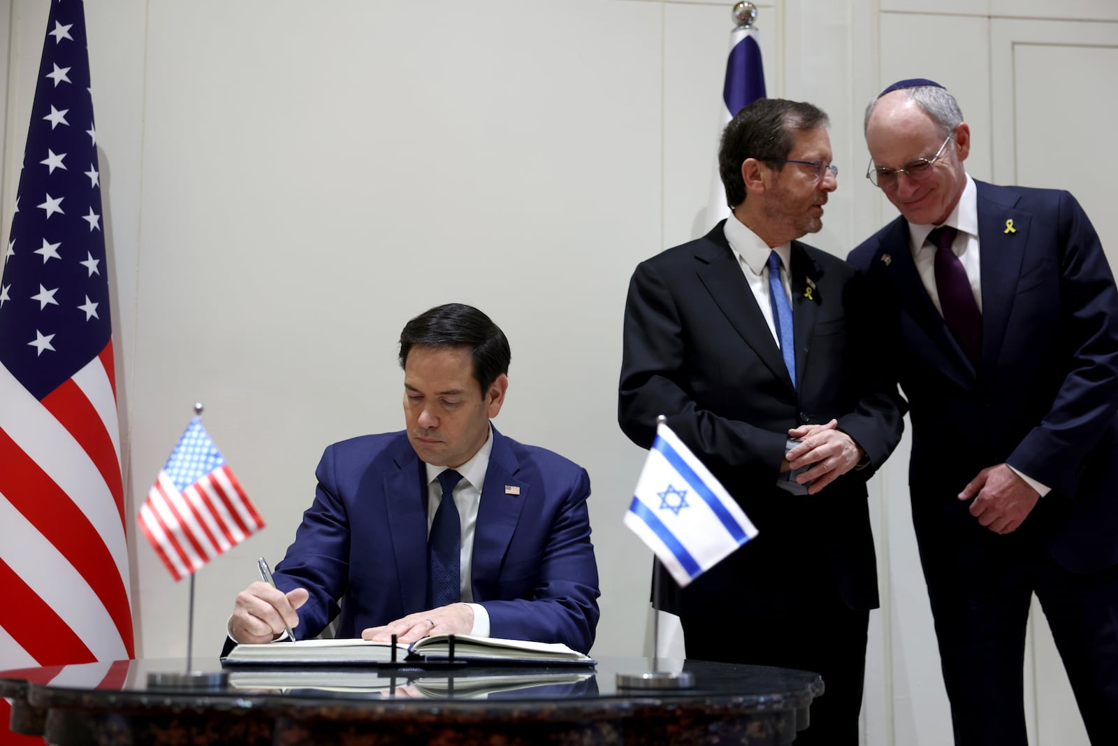 U.S. Secretary of State Marco Rubio signs the guest book during his meeting with Israeli President Isaac Herzog in Jerusalem, Israel, Sunday Feb. 16, 2025. (Evelyn Hockstein, Pool Photo via AP)