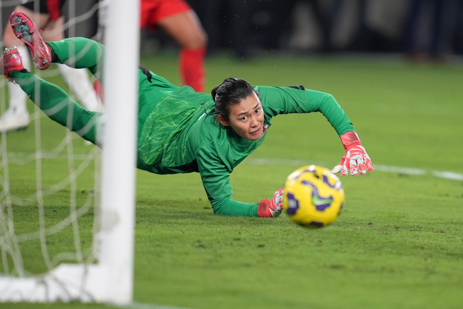 Japan goalkeeper Ayaka Yamashita watches as a shot from United States forward Catarina Macario just misses during the first half of a SheBelieves Cup women's soccer tournament match Wednesday, Feb. 26, 2025, in San Diego. (AP Photo/Gregory Bull)