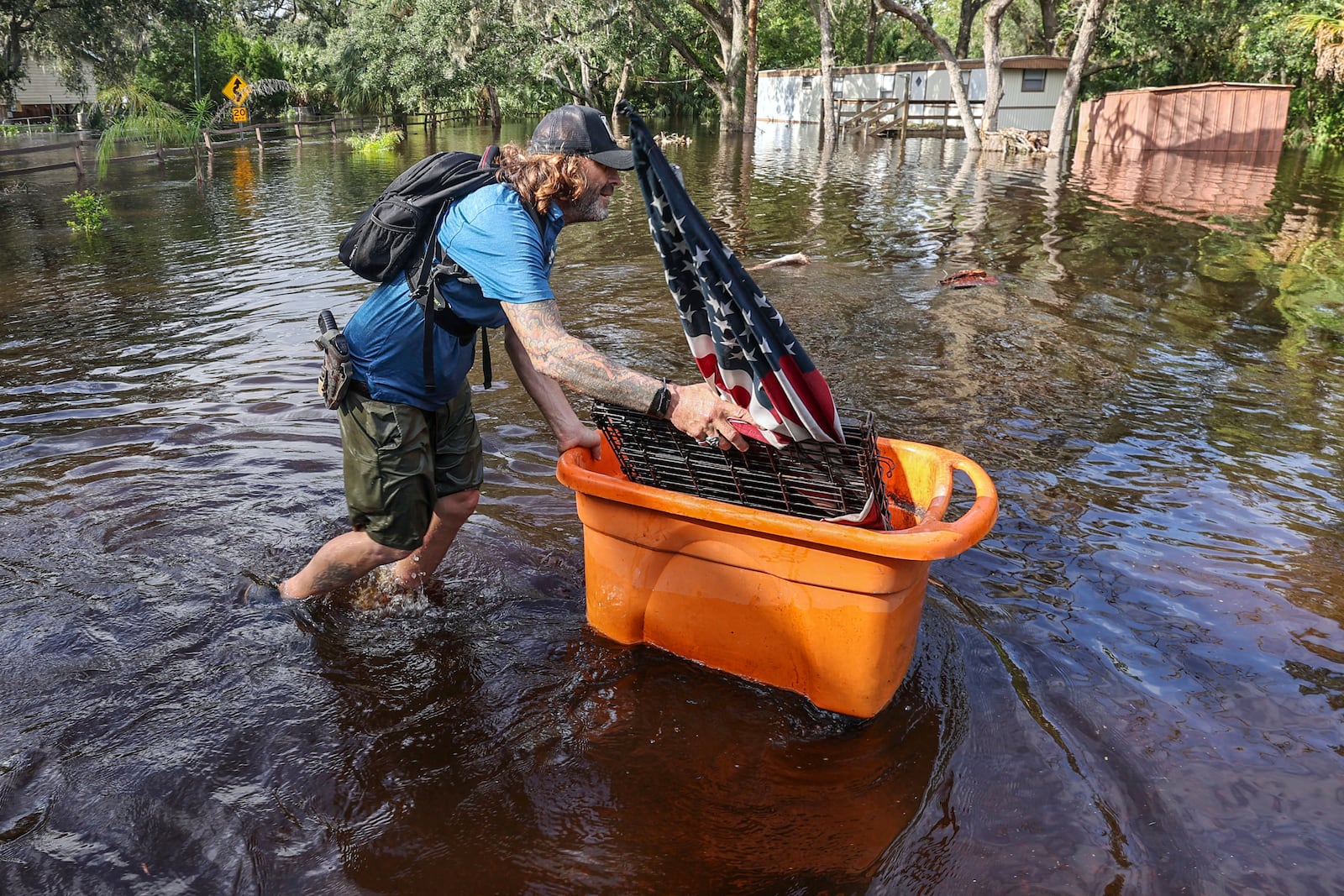 A man who identified himself as Jesse walks out through floodwaters of the Anclote River after Hurricane Milton hit the region, Thursday, Oct. 10, 2024, in New Port Richey, Fla. (AP Photo/Mike Carlson)