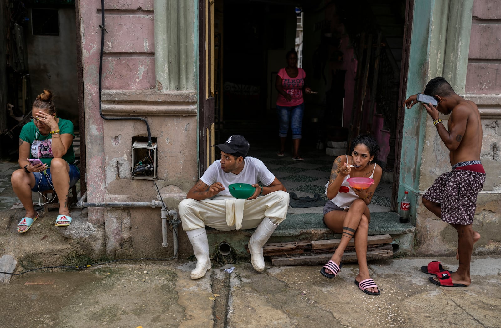 Residents eat outside their homes to avoid the indoor heat during a massive blackout after a major power plant failed in Havana, Cuba, Saturday, Oct. 19, 2024. (AP Photo/Ramon Espinosa)