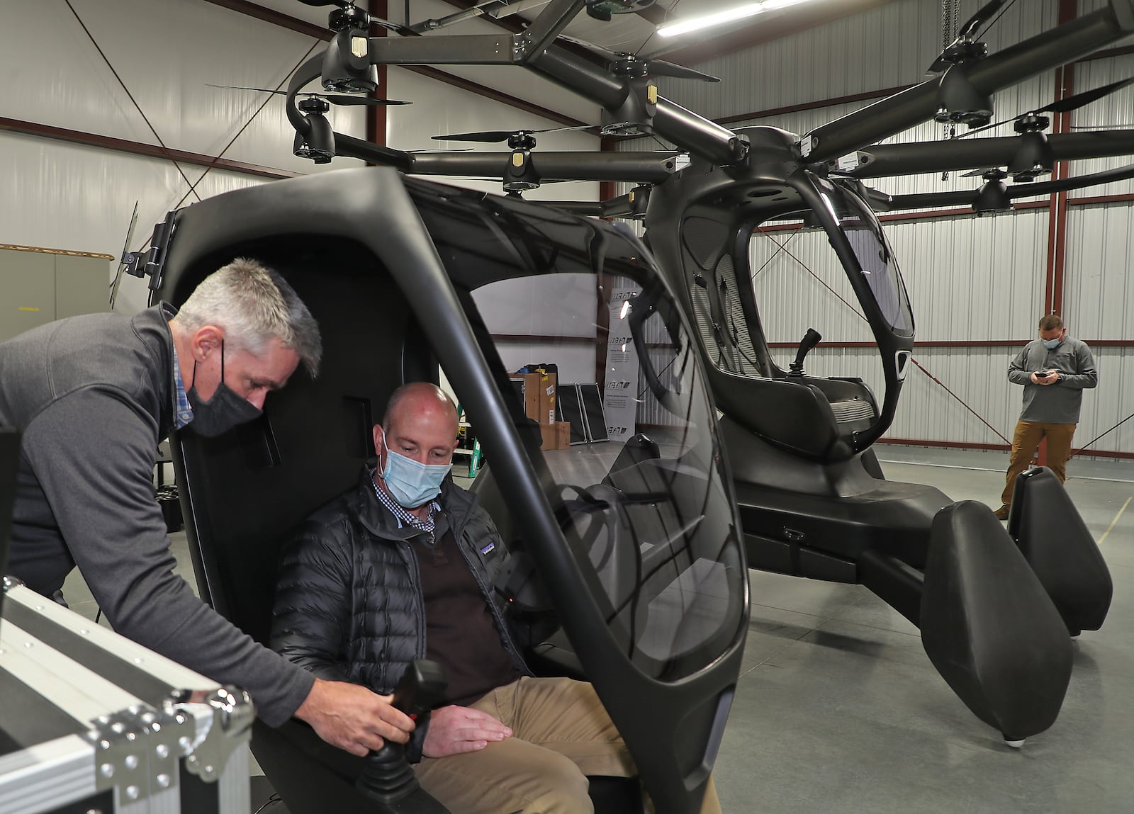 Matthew Chasen, CEO of LIFT Aircraft, instructs Tom Franzen,  Springfield Assistant City Manager, on how to fly LIFT Aircraft’s electric vertical takeoff and landing (eVTOL) vehicle at Springfield-Beckley Municipal Airport Friday. The “flying car” is the first to arrive in Ohio, and is supported by a recent $226,000 grant from JobsOhio’s Ohio Site Inventory Program in infrastructure investments at Springfield-Beckley Municipal Airport. BILL LACKEY/STAFF 