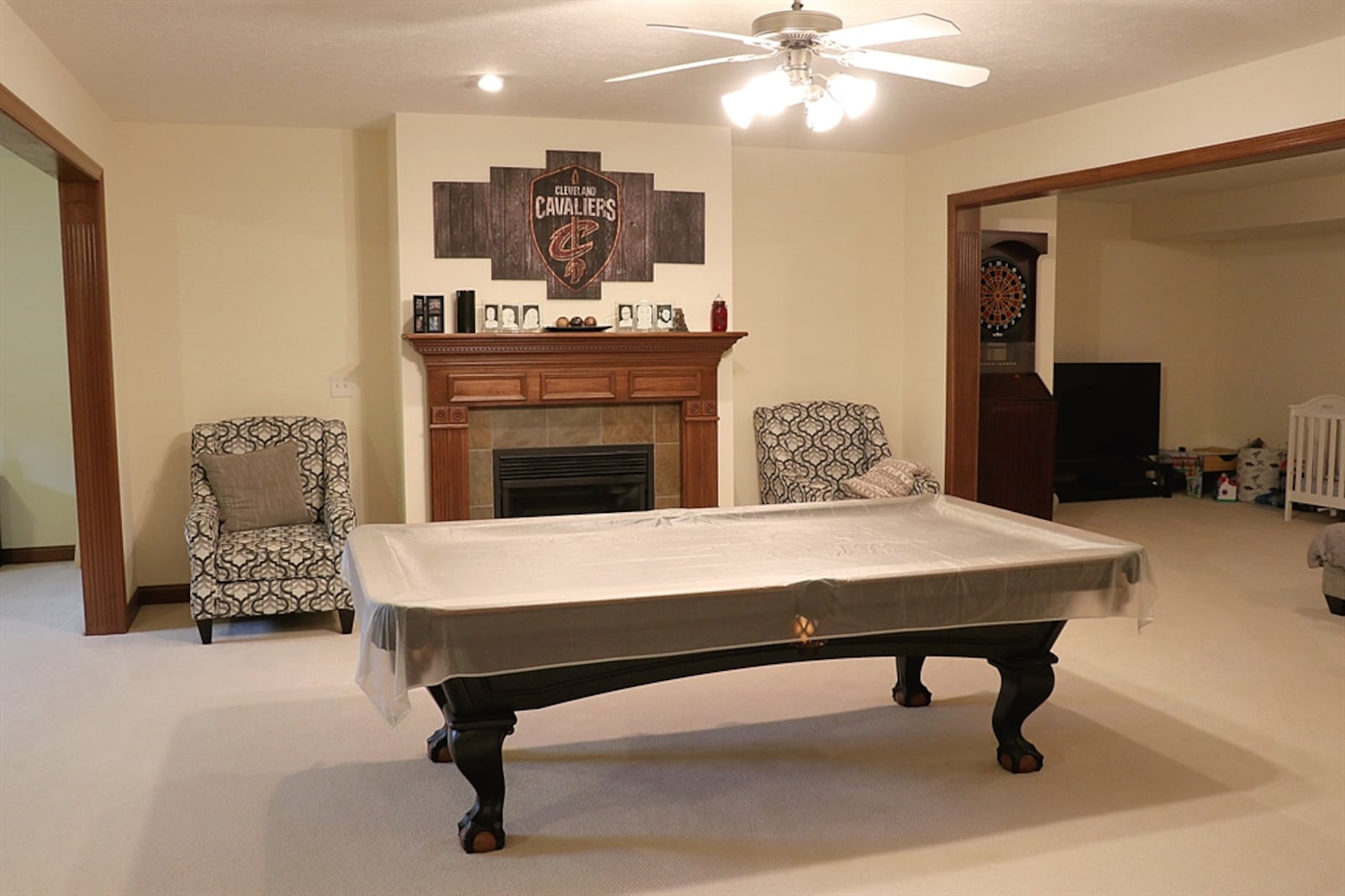 A gas fireplace with a tile hearth and wood mantel is at the center of the family room.