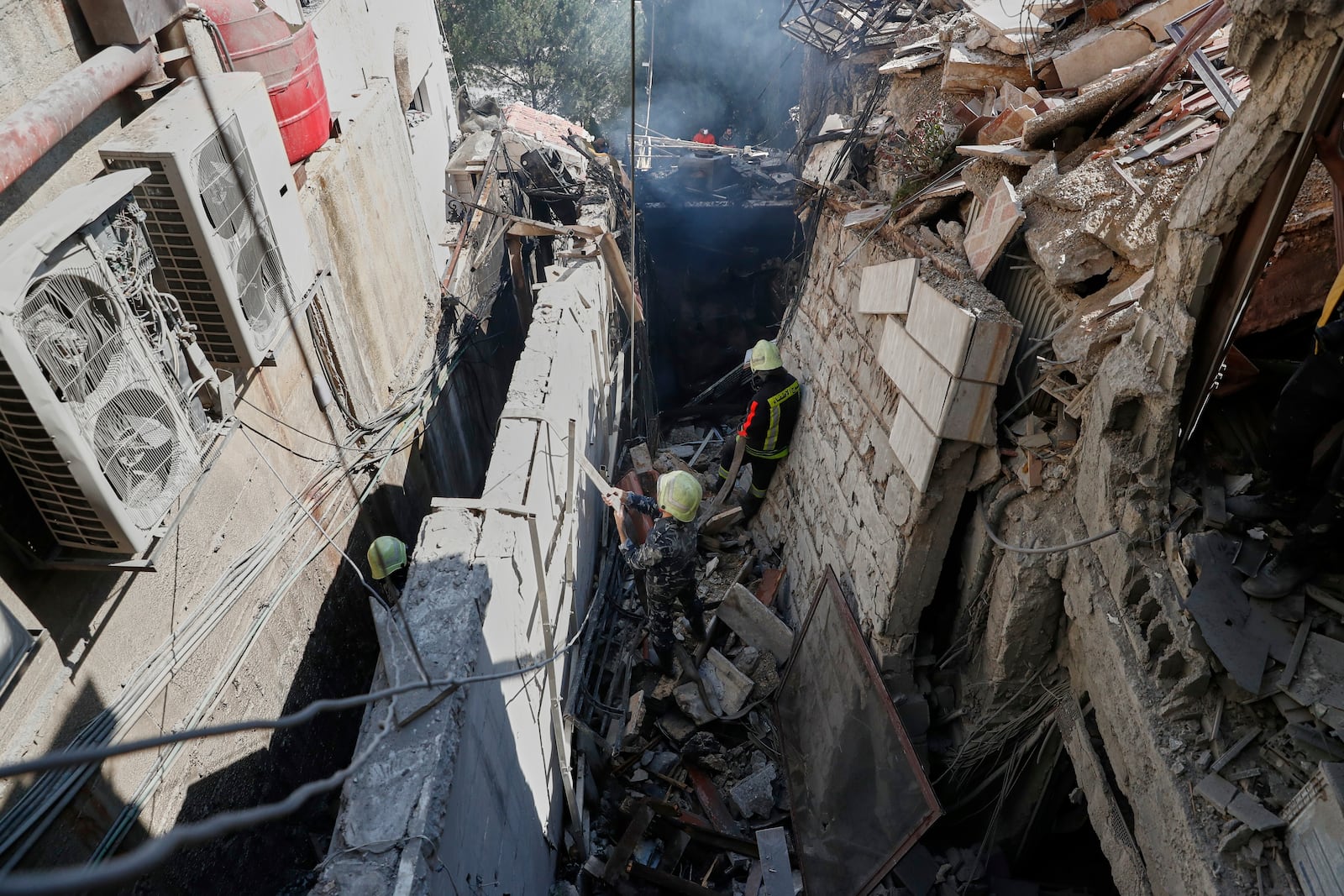 Firemen work at the site of an Israeli missile strike in Damascus, Syria, Thursday March 13, 2025.(AP Photo/Omar Sanadiki)