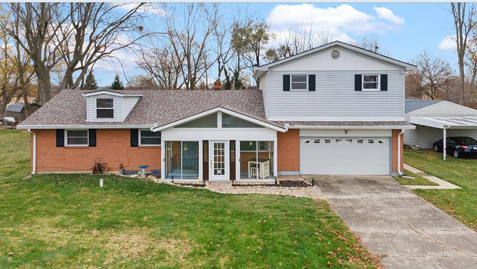 The front of the home features a fully enclosed front porch and two-car attached garage.