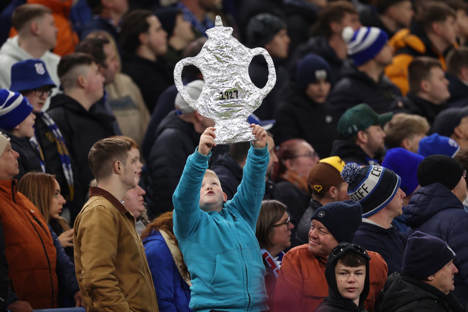 A Cardiff City's fan holds a mockup of the trophy during the English FA Cup fifth round soccer match between Aston Villa and Cardiff City at the Villa Park stadium in Birmingham, England, Friday, Feb. 28, 2025. (AP Photo/Darren Staples)