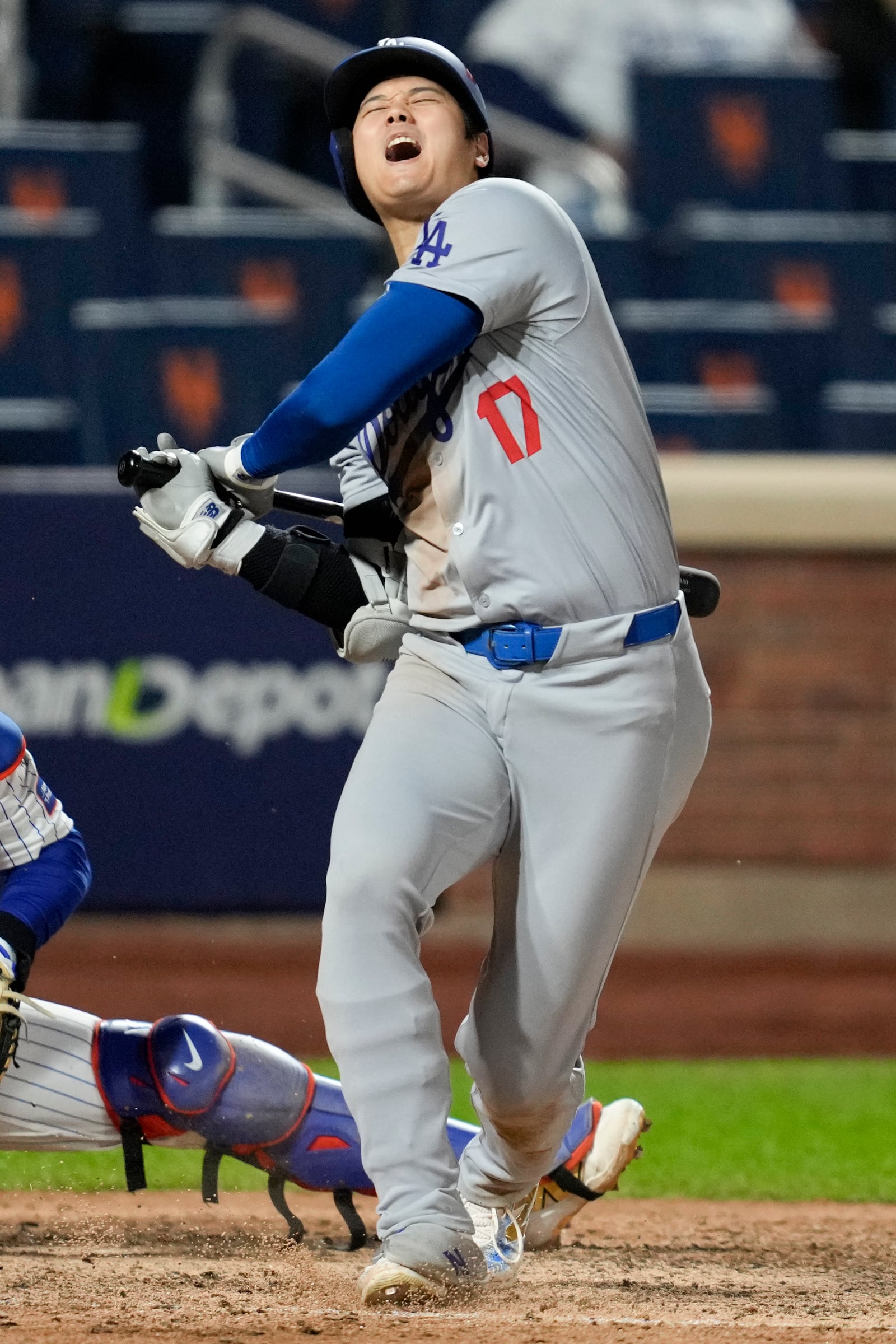 Los Angeles Dodgers' Shohei Ohtani reacts after getting hit with a foul ball during the eighth inning in Game 4 of a baseball NL Championship Series against the New York Mets, Thursday, Oct. 17, 2024, in New York. (AP Photo/Ashley Landis)