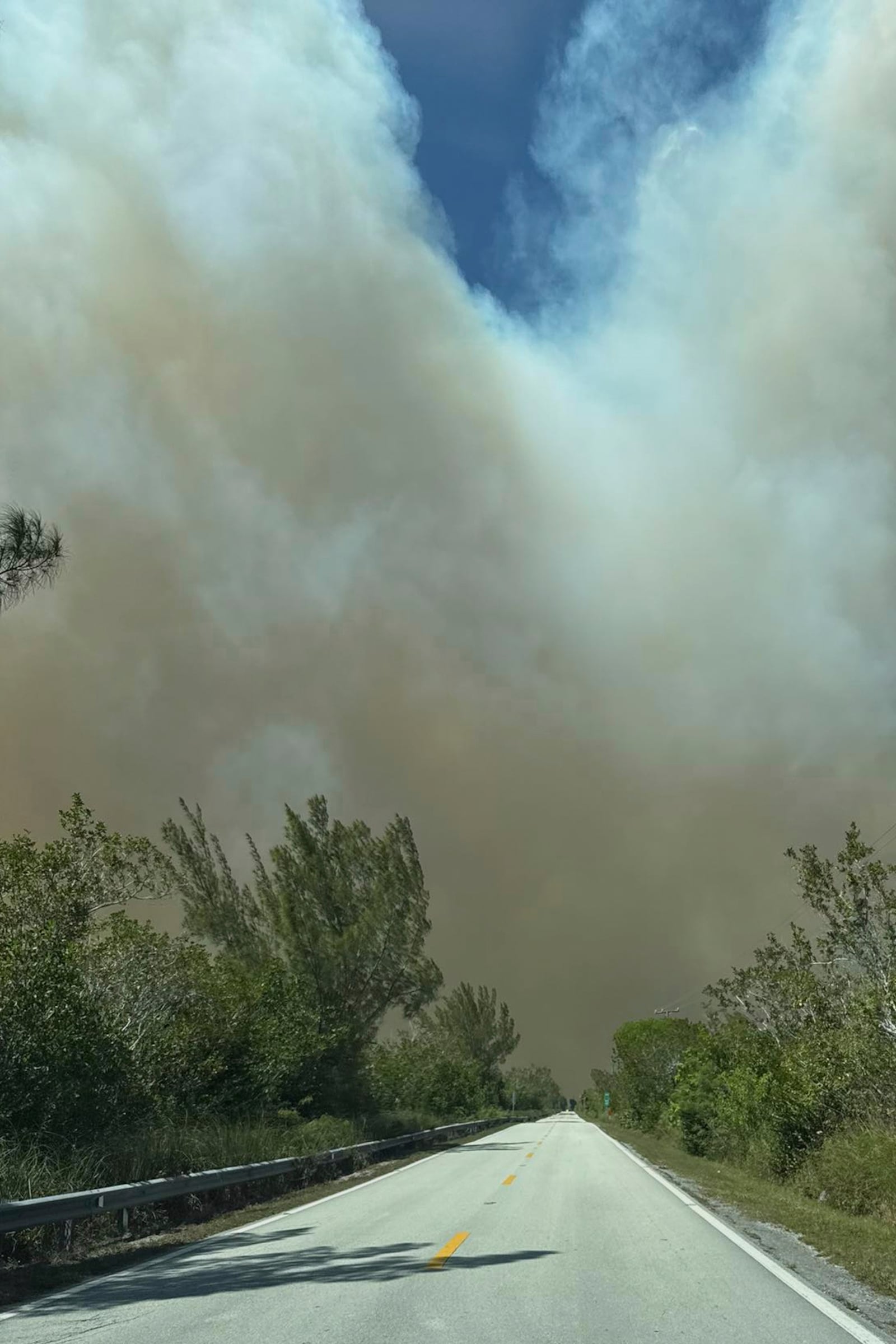 This photo provided by shows smoking from fires on Miami-Dade side fill the sky on Card Sound Road heading to the Florida Keys on Tuesday, March 18, 2025. (Monroe County Board of County Commissioners via AP)