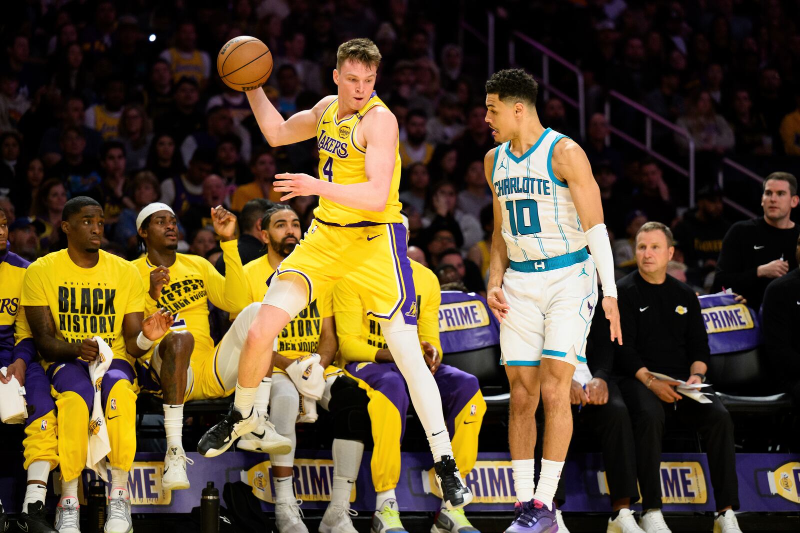 Los Angeles Lakers guard Dalton Knecht (4) tries to throw the ball off of Charlotte Hornets guard Josh Green (10) during the first half of an NBA basketball game Wednesday, Feb. 19, 2025, in Los Angeles. (AP Photo/William Liang)