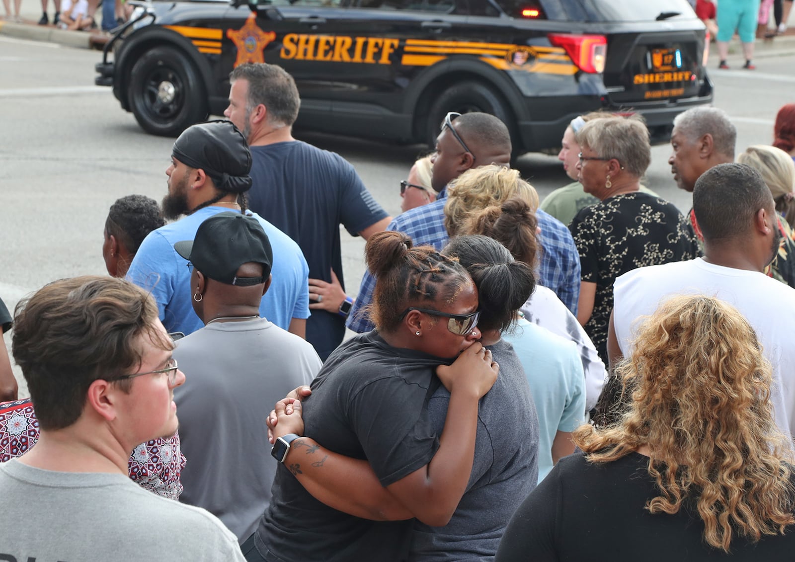 Two women console each other as the procession with Deputy Matthew Yates' body drives past Monday in downtown Springfield. BILL LACKEY/STAFF