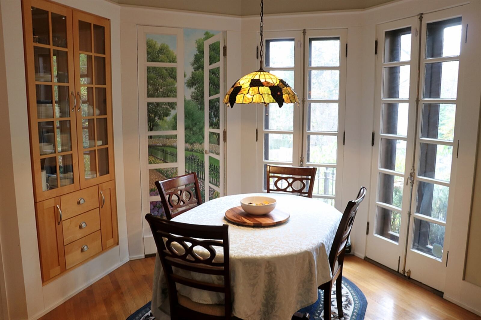 The bay-like breakfast room has French patio doors that open to the upper paver-brick patio. Along one wall of the breakfast room is a built-in china hutch with lighted shelves behind glass-panel doors.