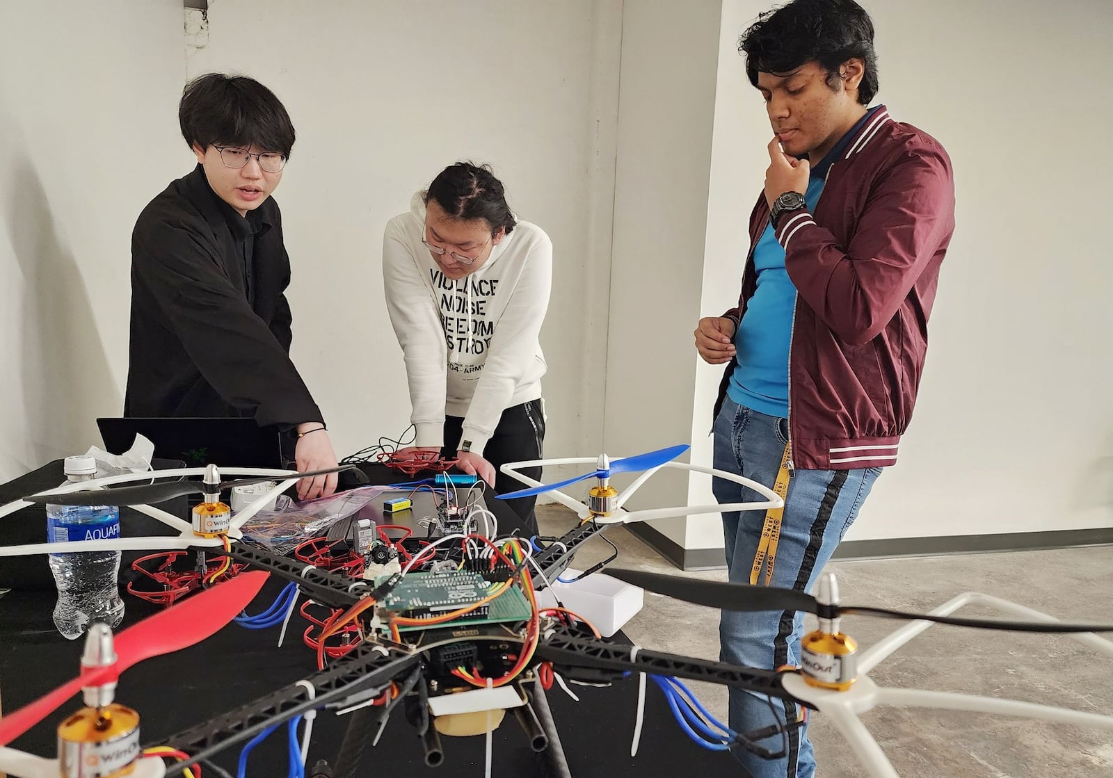 Jie Feng, left, Rui Yang, middle, and Tanmay Bhatkar demonstrates some of the drone technology they are working on in Department of Electrical and Computer Engineering at Miami University during a launch event and ribbon cutting of the new Lee and Rosemary Fisher Innovation College@Elm was held on Thursday, Feb. 16, 2023 in Oxford. The building is aimed at incubating and accelerating entrepreneurs, startup and small businesses and offering the training and workforce education necessary to produce Ohio’s future manufacturing and high-tech workforce. NICK GRAHAM/STAFF