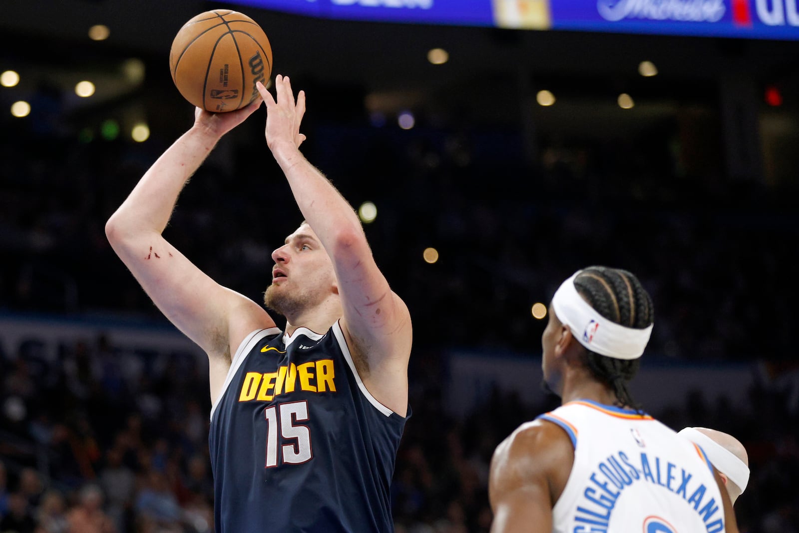 Denver Nuggets center Nikola Jokic (15) looks to shoot as Oklahoma City Thunder guard Shai Gilgeous-Alexander, right, watches during the second half of an NBA basketball game Monday, March 10, 2025, in Oklahoma City. (AP Photo/Nate Billings)