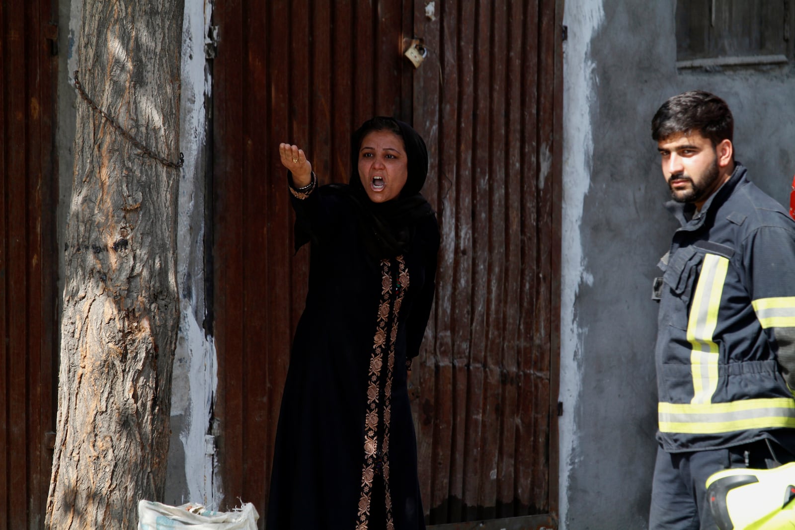 An Afghan woman shouts to protest against the Afghan government after an explosion near her home in Kabul, Afghanistan, Wednesday, Sept. 9, 2020. Spokesman for Afghanistan's Interior Ministry said the bombing that targeted the convoy of the country's first vice president on Wednesday morning killed several people and wounded more than a dozen others, including several of the vice president's bodyguards. (AP Photo/Rahmat Gul)